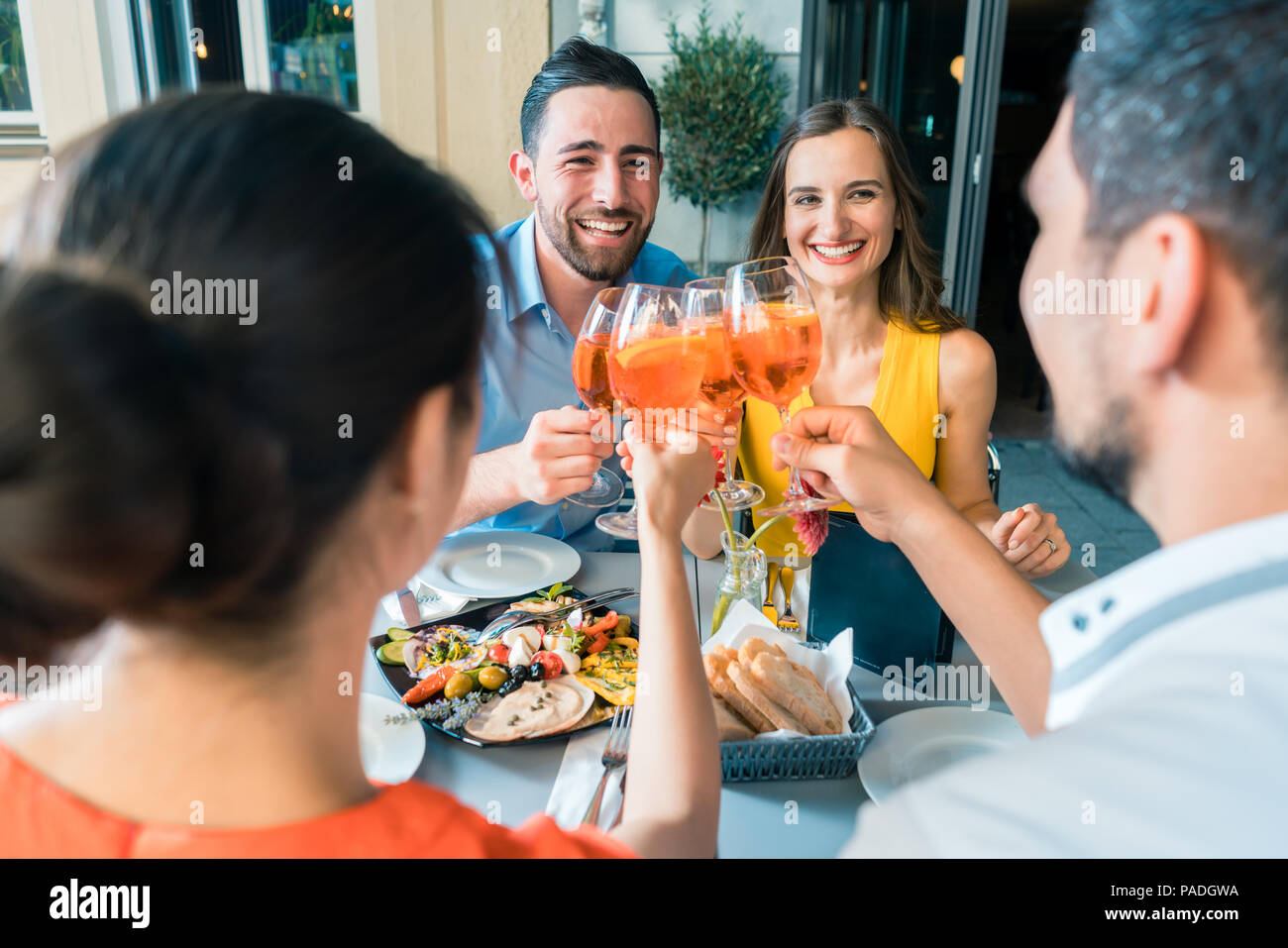 Quatre amis avec un grillage rempli de boisson alcoolisée Banque D'Images