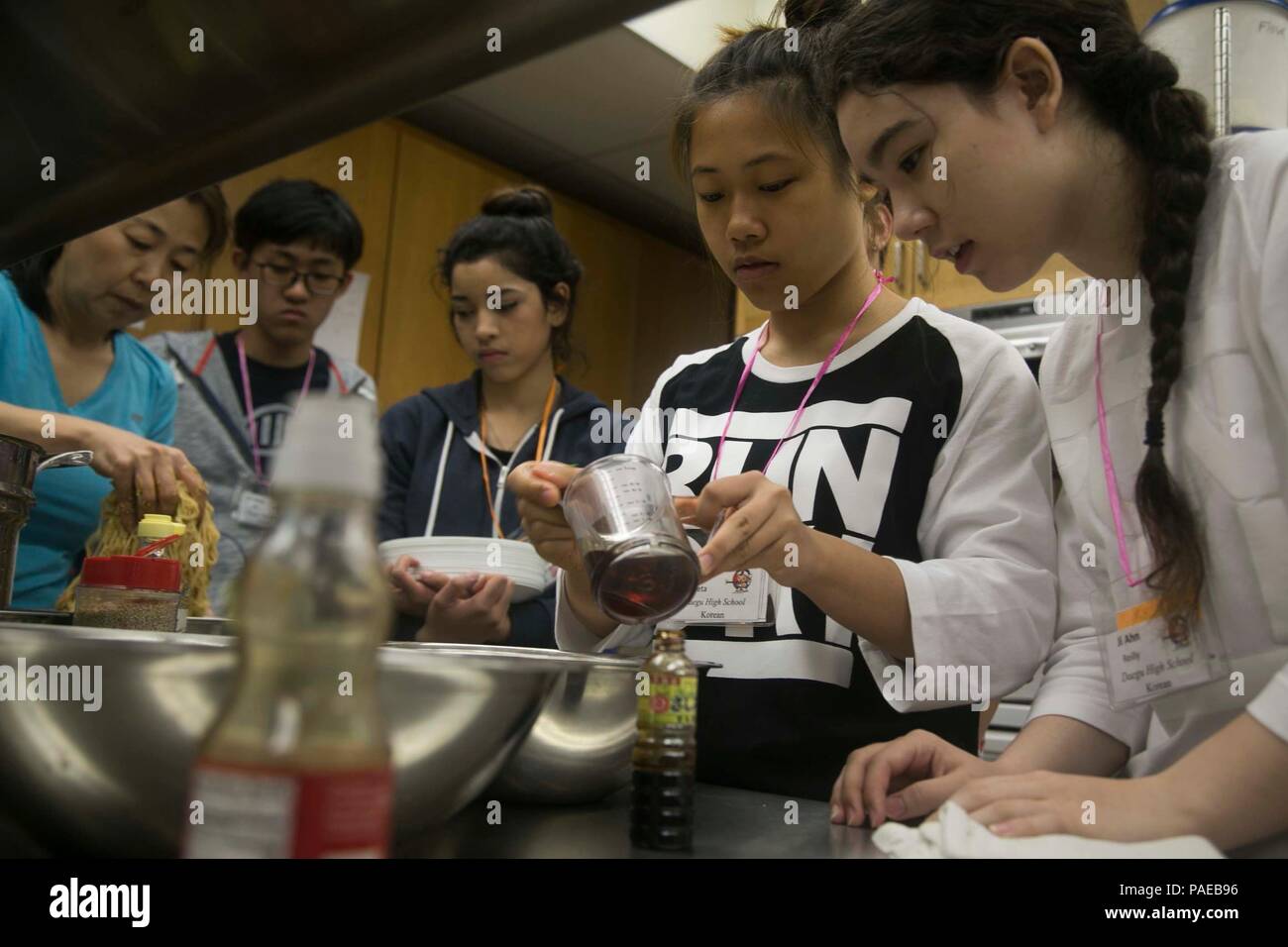 Les étudiants de Linguafest 2016 préparent le Bibim Guksu, un plat traditionnel coréen de nouilles mixtes, dans le cadre d'une éducation culinaire interculturelle. Le programme d'une semaine rassemble plus de 100 élèves des lycées du DOD en Corée, à Guam et au Japon. Les étudiants s'engagent dans des activités d'apprentissage des langues en japonais, chinois, coréen, français, espagnol, et allemand, tout en participant également à la cuisine, à l'exploration culturelle, au travail d'équipe et à l'apprentissage expérientiel qui favorise la croissance éducative et la compréhension interculturelle. Banque D'Images
