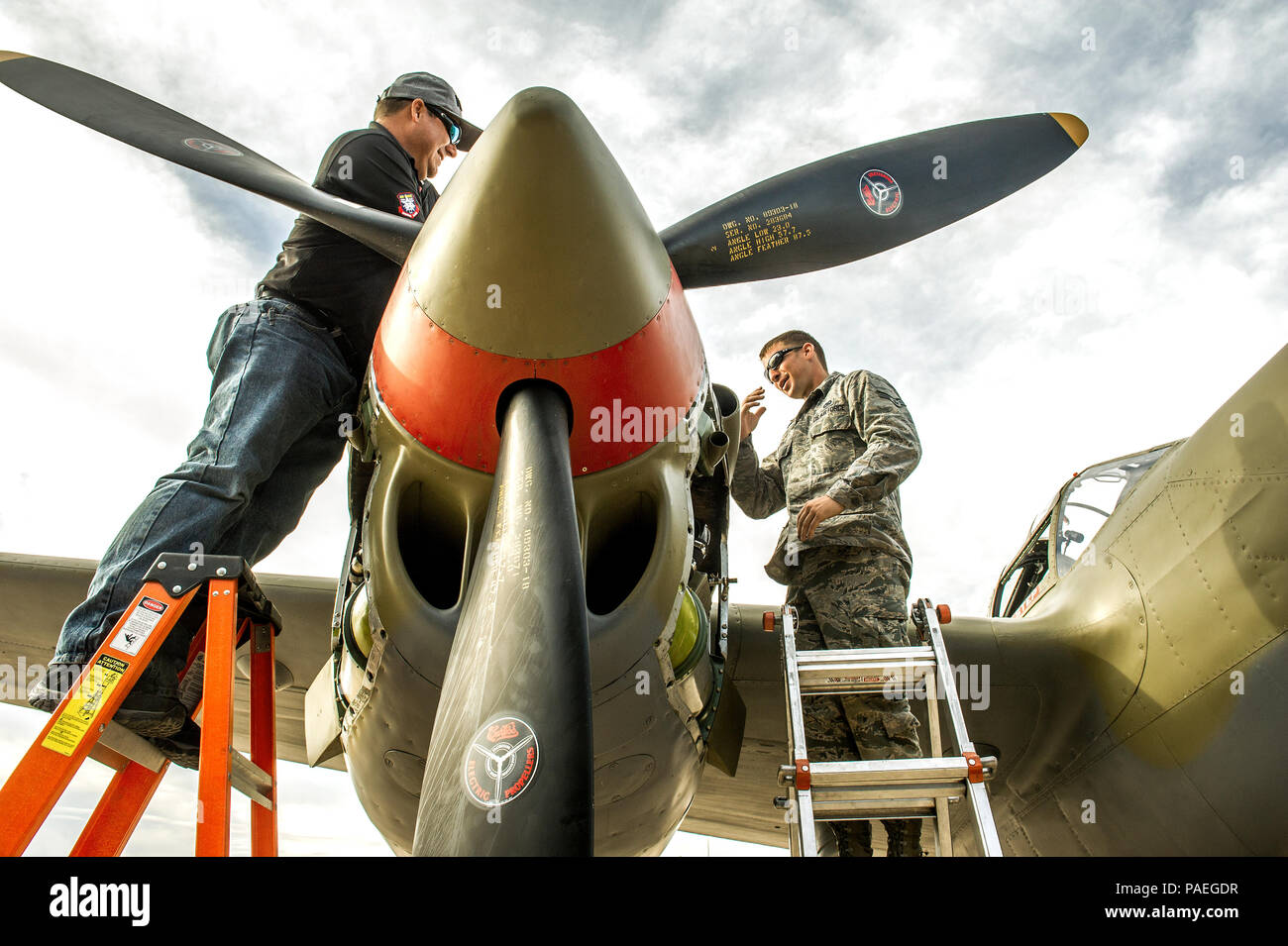 Anthony Naugle Senior Airman, droit, l'A-10 le chef d'équipe avec le 357e Escadron de chasse, 355e Fighter Group basé à la base aérienne Davis-Monthan AFB, Tucson (Arizona), obtient une leçon dans le maintien de l'un des deux 1 000 kW (746 hp), turbo-compresseur, 12 cylindres moteurs Allison V-1710 sur un P-38 Lightning de Abshier après leur journée de pratique des vols à la formation de vol du patrimoine, Mar 5, 2016. (U.S. Air Force photo par J.M. Eddins Jr.) Banque D'Images