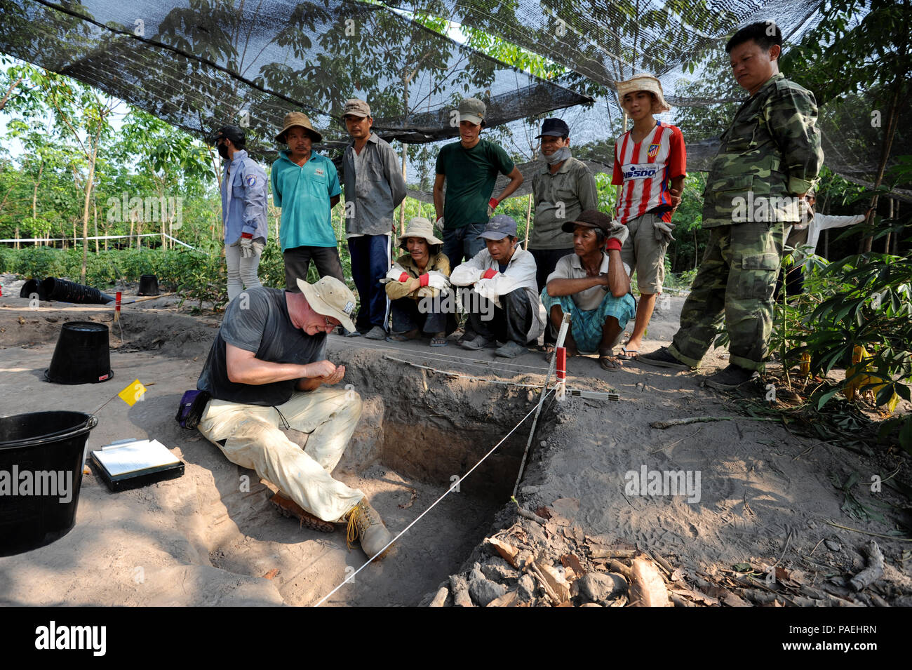 Scott Watson, un archéologue de l'Army Corps of Engineers des États-Unis, examine le sol d'un chantier de fouilles dans la province de Tay Ninh, Vietnam, comme les travailleurs locaux, regardez sur Mars 14, 2016. Watson est un leader de récupération pour la défense POW/MIA Agence Comptable (DPAA), et fait partie d'une équipe de rétablissement déployés à la recherche de deux membres du Service perdu dans un accident d'avion L-19 en 1967. La DPAA a pour mission de fournir à la comptabilité la plus complète possible pour nos employés manquants à leurs familles et à la nation. (DoD photo de Tech. Le Sgt. Kathrine Dodd, USAF/libérés) Banque D'Images