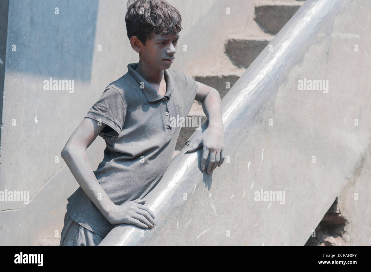 Dhaka, Bangladesh - 04 mai 2016 : un enfant travailleur couvert de poussière d'aluminium est vue à une petite usine à Dhaka. Le travail des enfants n'est pas une nouveauté en Ba Banque D'Images