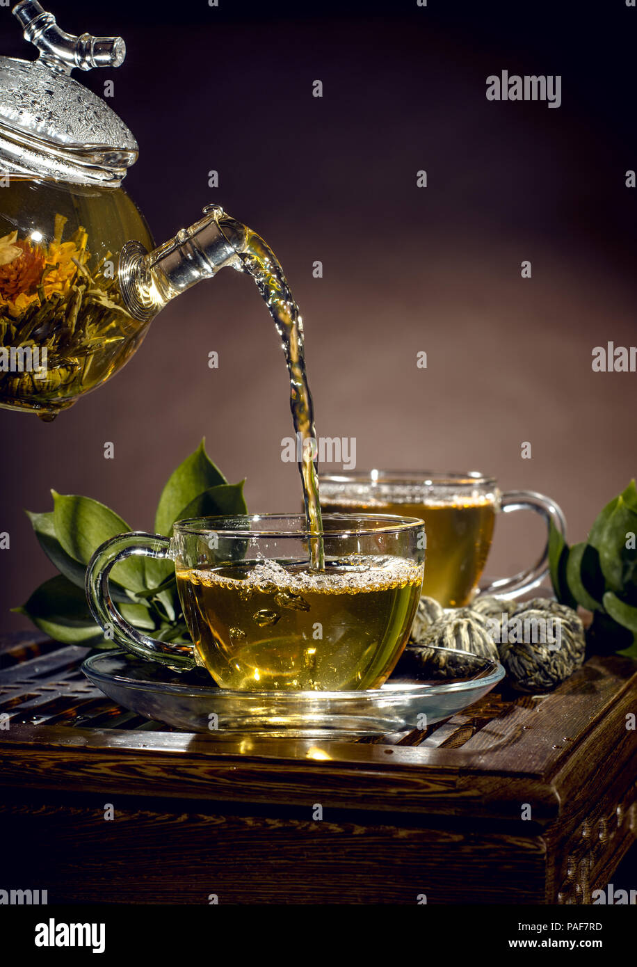 Théière en verre tasse thé vert en débit sur fond brun, cérémonie du thé Banque D'Images