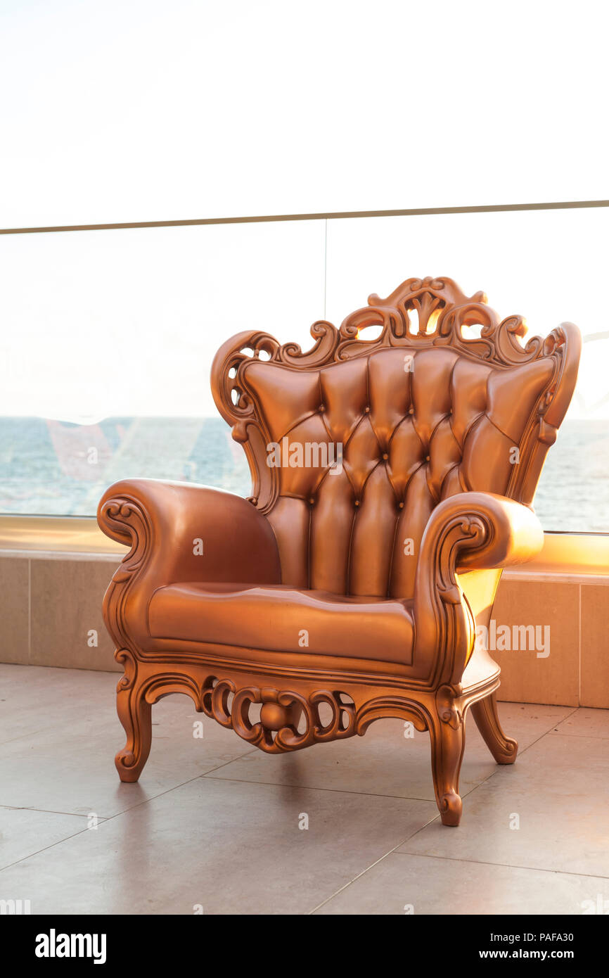 Chaise ancienne en or sur terrasse contre la mer Banque D'Images