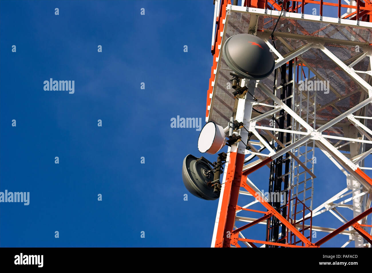 La tour rouge et blanc de la communication avec leurs antennes contre le ciel bleu Banque D'Images