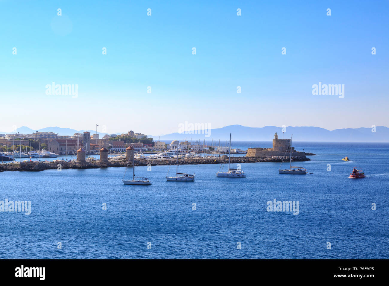 Les moulins à vent et la tour St Nicolas et le phare de port de Mandraki à Rhodes, Dodécanèse, Grèce Banque D'Images