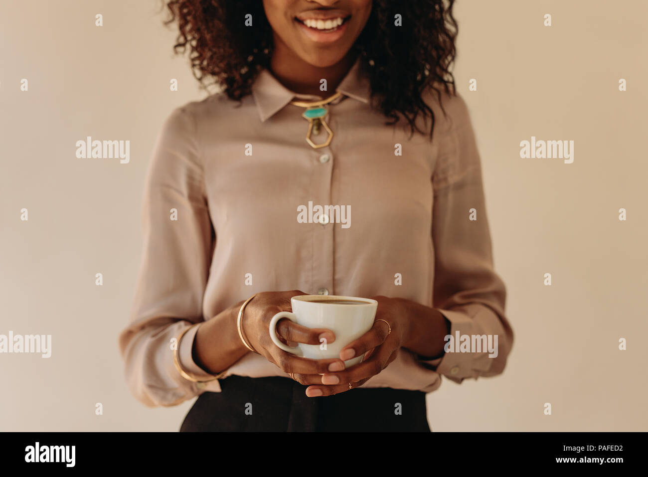 Close up of smiling woman holding une tasse de café dans les mains. Banque D'Images