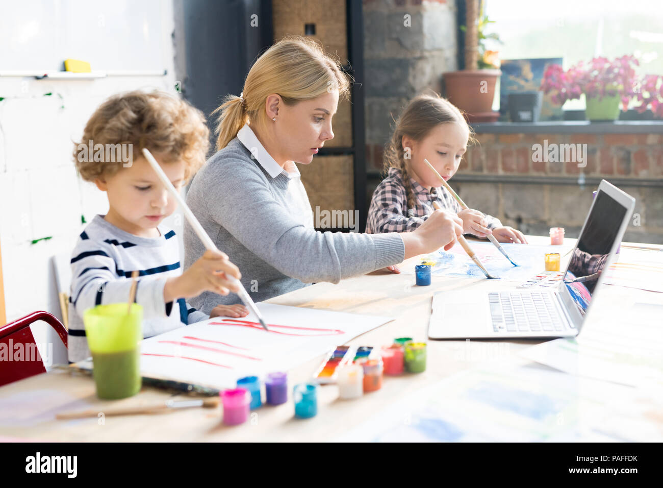 Peinture enfants avec l'enseignant Banque D'Images