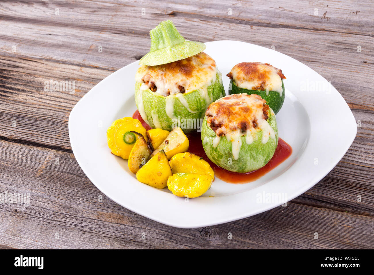 Courgette farcie ronde balle avec le quinoa et fromage servi avec poivrons patty pan squash Banque D'Images