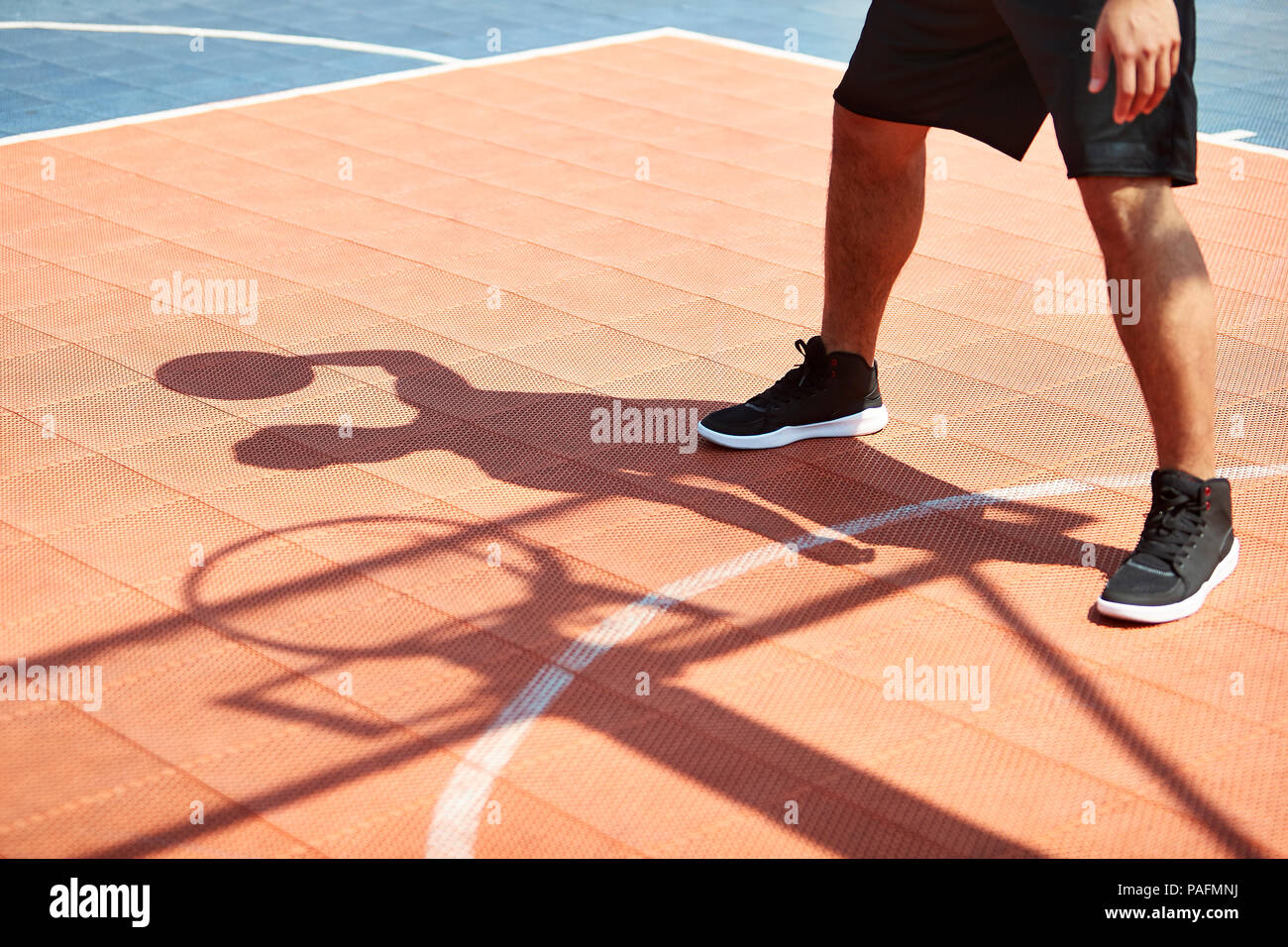 Les jeunes adultes asiatiques jouant au basket-ball sous soleil de l'été sur une cour. Banque D'Images