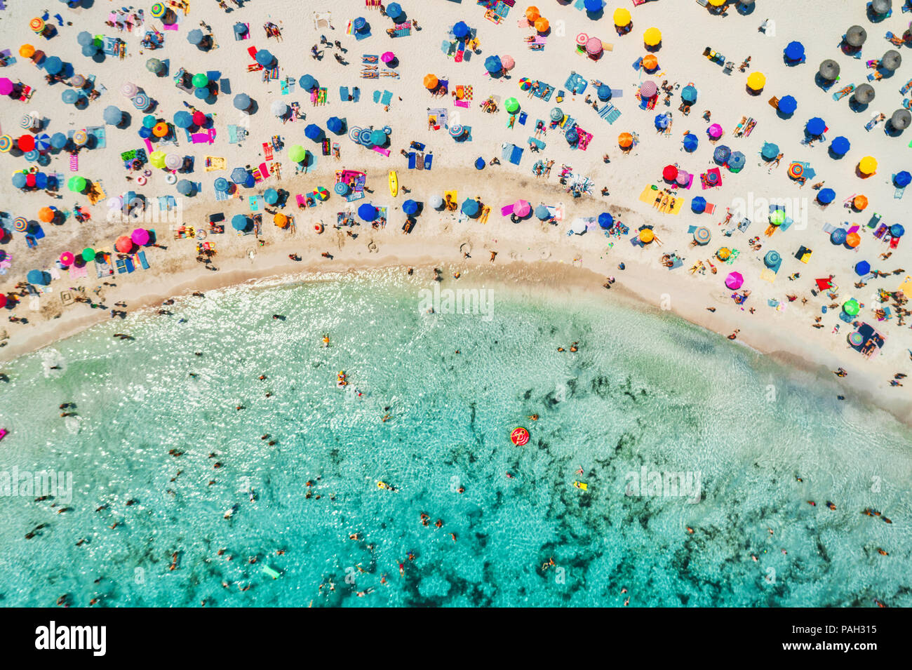 Vue aérienne de la plage de sable fin avec parasols colorés, d'une personnes dans la baie de la mer avec de l'eau d'un bleu transparent en matinée ensoleillée en été. En voyage Mallo Banque D'Images