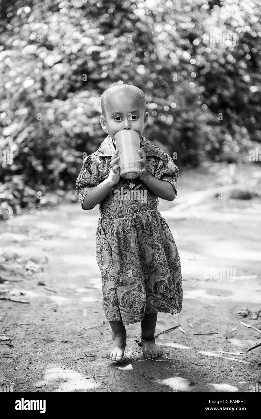 OMO, ETHIOPIE - 20 septembre 2011 : belle petite fille éthiopienne non identifiés avec une tasse d'eau jaune. La population en Éthiopie souffrent de la pauvreté en raison Banque D'Images