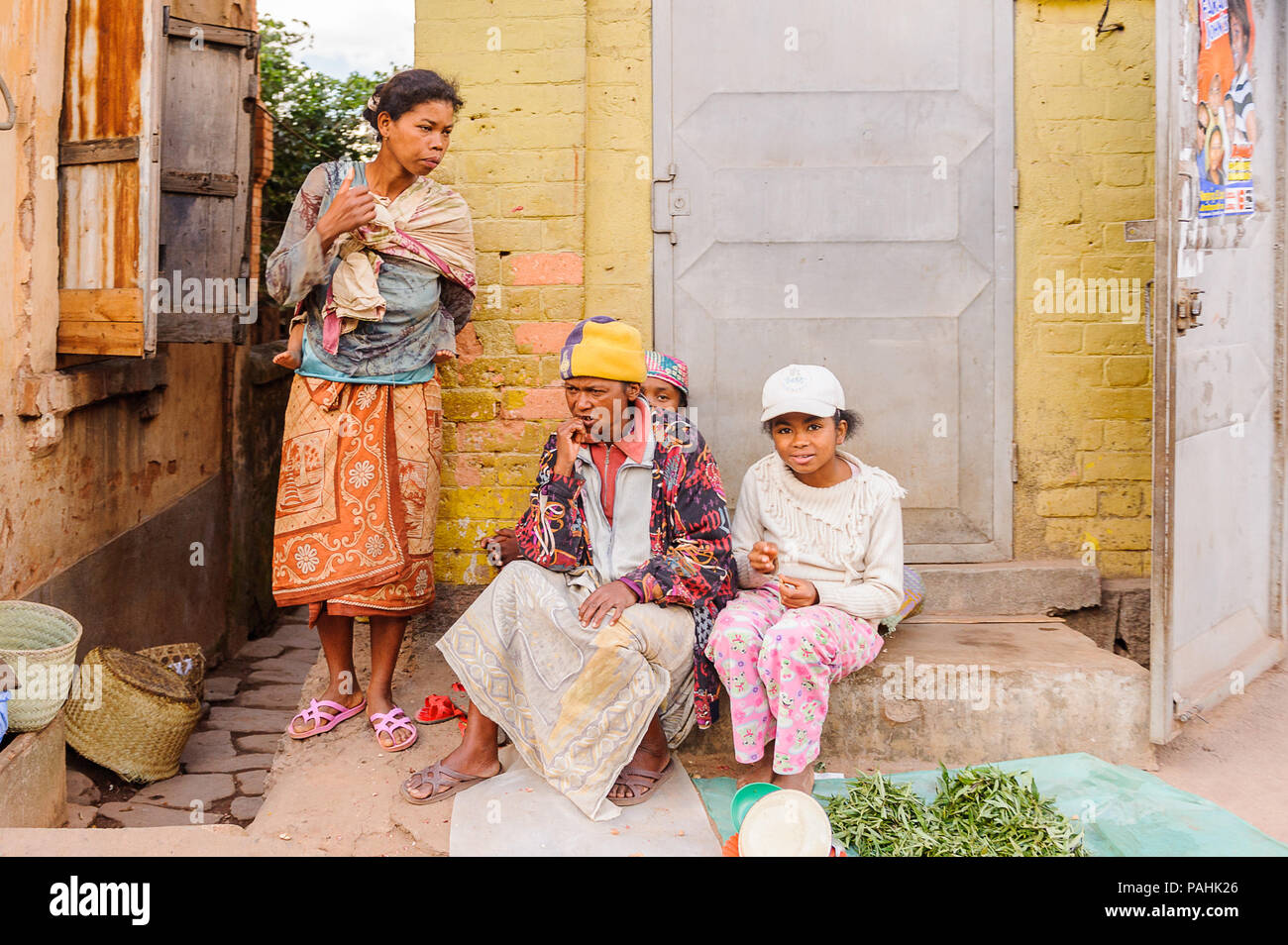 ANTANANARIVO, MADAGASCAR - 30 juin 2011 : les femmes avec enfants Madagascar non identifiés s'asseoir à la véranda. Les gens souffrent de la pauvreté à Madagascar en raison de Banque D'Images