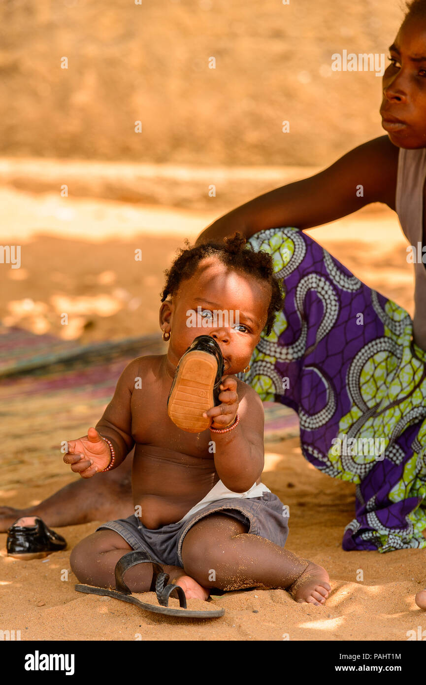 Lomé, Togo - Mar 9, 2013 Le Réseau non identifié : cute little baby girl met une chaussure dans la bouche. Peuple Togolais souffrent de la pauvreté en raison de l'instabilité de l'éco Banque D'Images