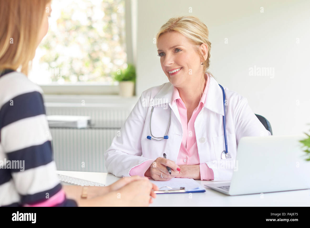 Femme médecin assis au bureau du médecin avec son patient et de consultation sur le diagnostic. Banque D'Images