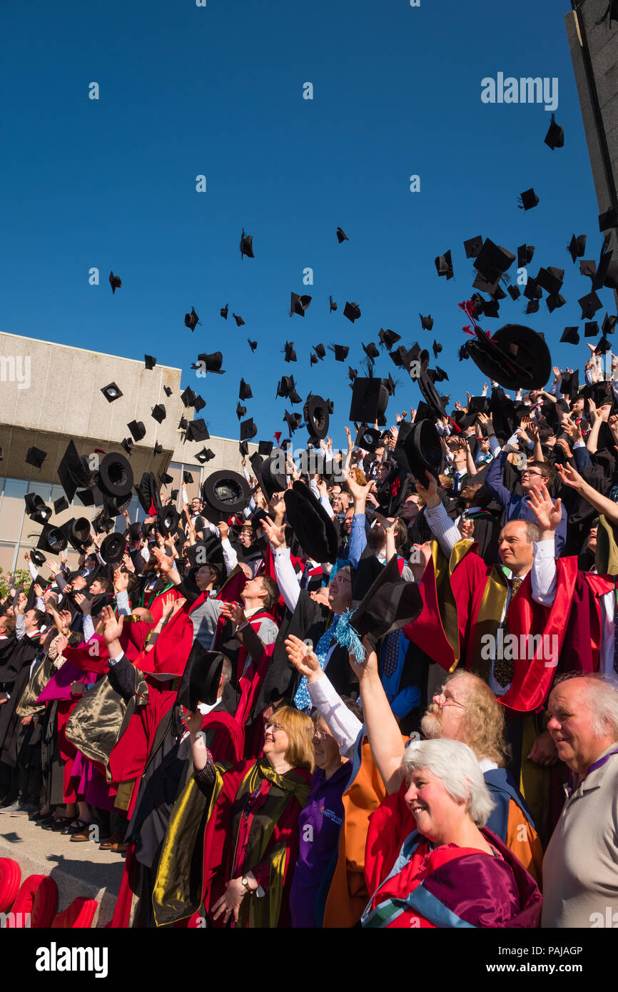L'enseignement supérieur au Royaume-Uni : les finissants d'université d'Aberystwyth, jetant leurs capuchons et les conseils de mortier dans l'air pour le traditionnel diplôme photo. Juillet 2018 Banque D'Images