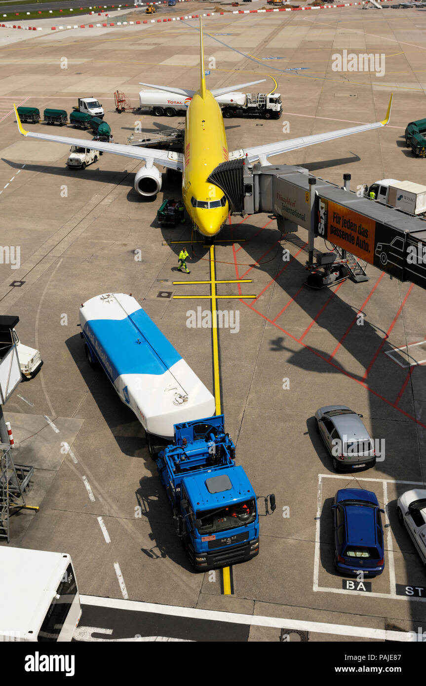 Avitailleurs de ravitaillement, des chariots à bagages avec tracteur et  TUIfly garé avec Boeing 737-800 de jetway attaché Photo Stock - Alamy