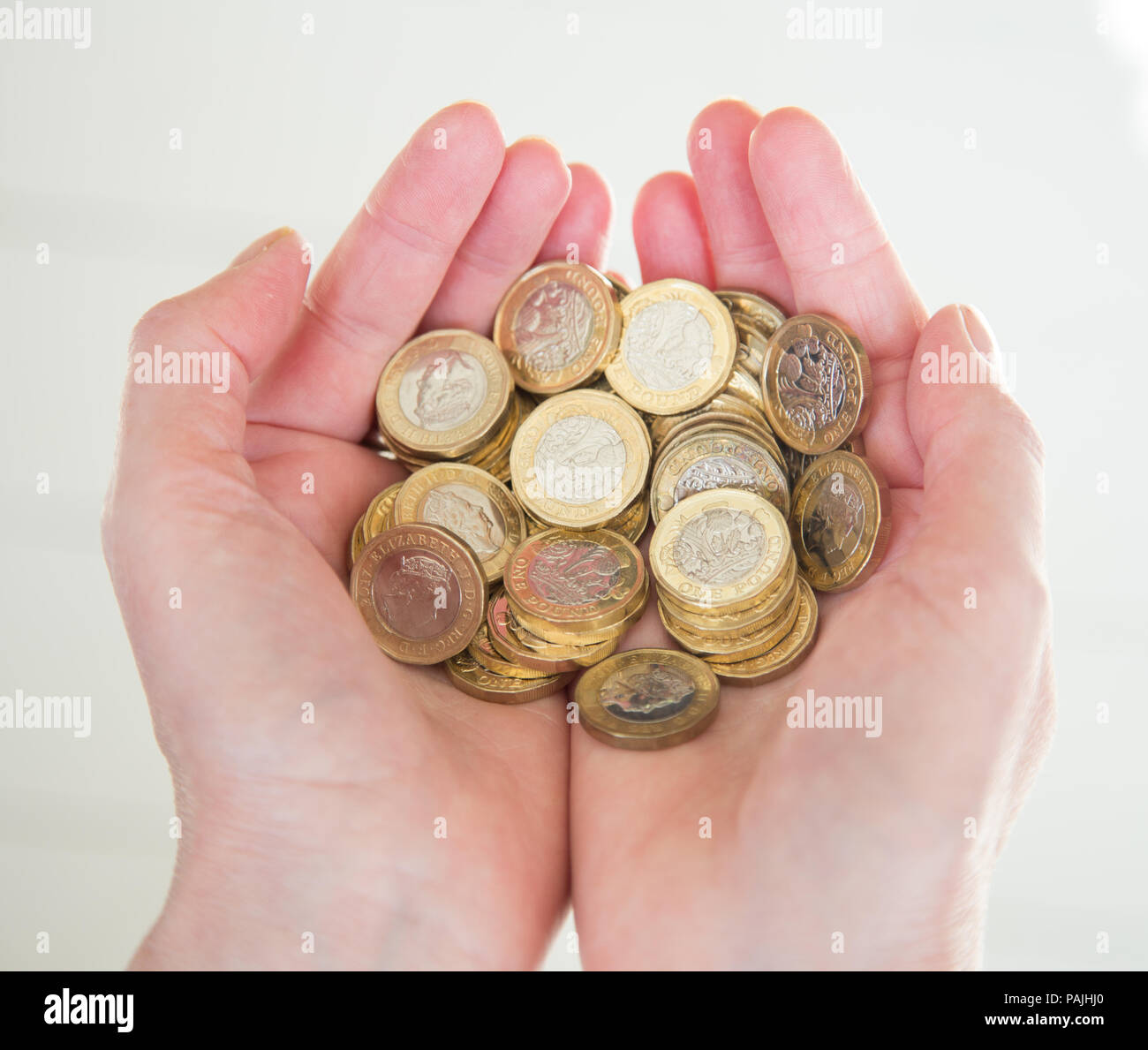 Close-up of a woman's hands holding une pile de pièces livre Banque D'Images