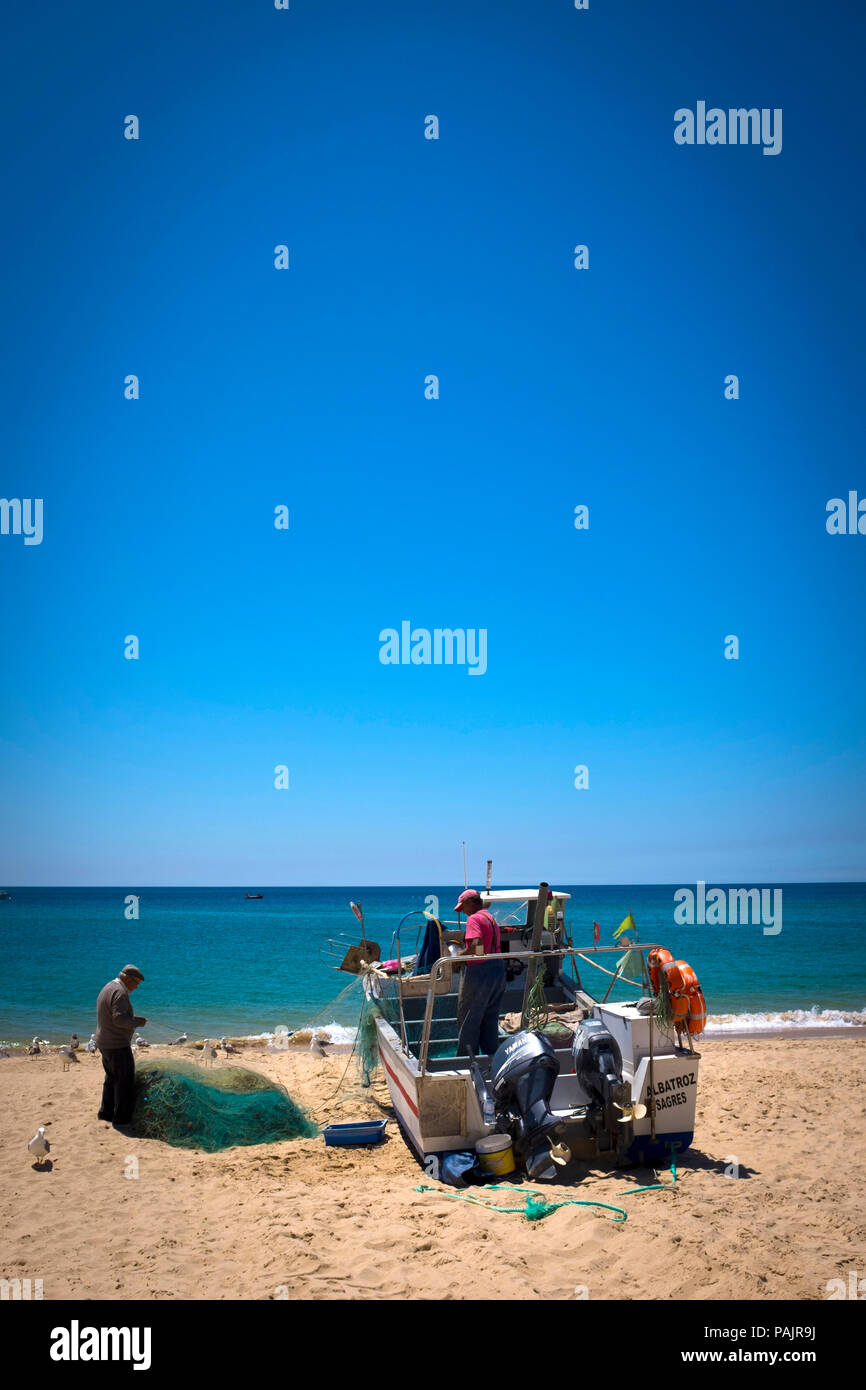 Nettoyage des petits pêcheurs leurs filets, dans Salema, Algarve, Portugal. Banque D'Images