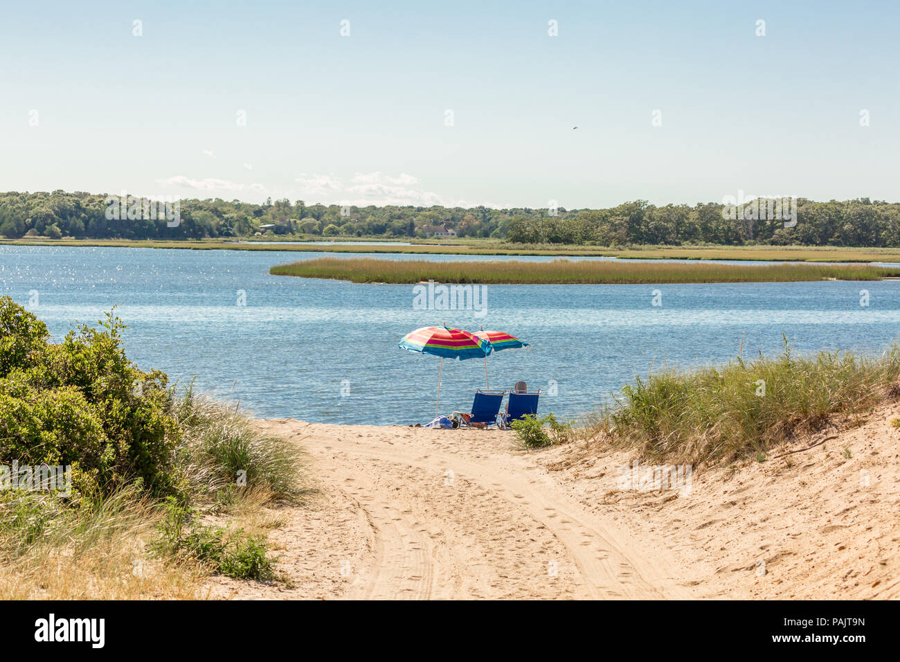Un couple assis sous les parasols à la plage de baie dans East Hampton, NY Banque D'Images