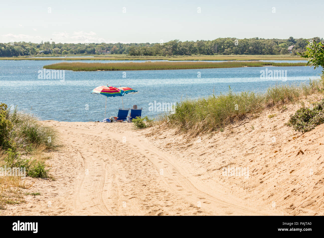Un couple assis sous les parasols à la plage de baie dans East Hampton, NY Banque D'Images
