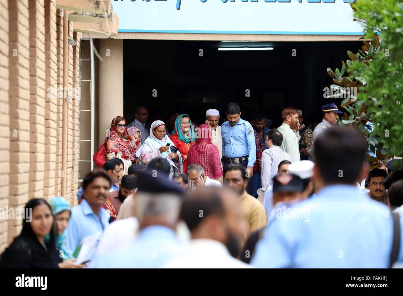 Islamabad, Pakistan. 24 juillet, 2018. Les fonctionnaires électoraux attendent de recevoir les boîtes et le matériel de vote à un centre de distribution à Islamabad, capitale du Pakistan, le 24 juillet 2018. Le Pakistan va tenir ses élections générales le 25 juillet. Credit : Ahmad Kamal/Xinhua/Alamy Live News Banque D'Images