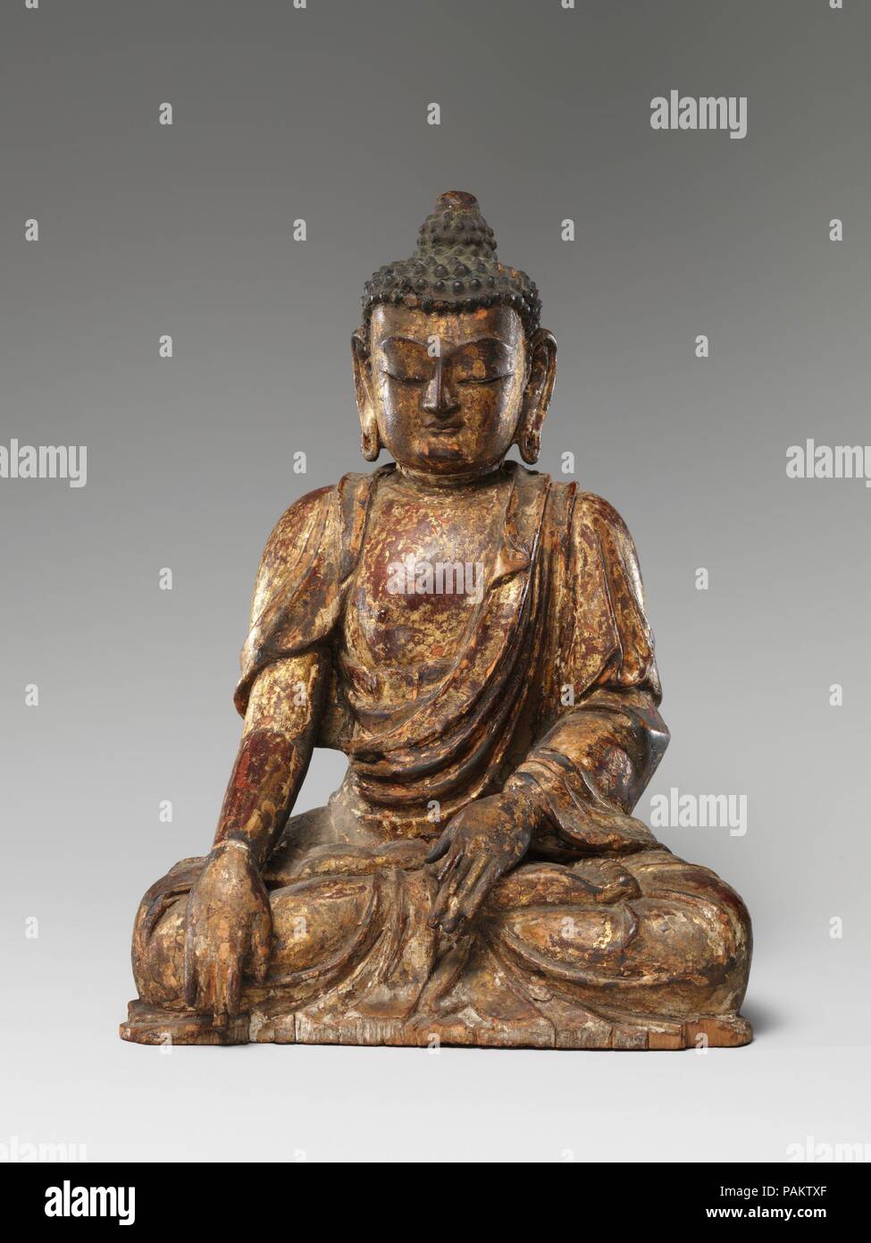 Bouddha, probablement Akshobhya (Achu fo). Culture : la Chine. Dimensions : H. 9 1/4 in. (23,5 cm) ; W. 6 1/2 in. (16,5 cm) ; D. 4 1/4 in. (10,8 cm). Date : du 1411. Le Bouddha est représenté dans l'attitude de la prédication d'un doigt de la main droite étendue à la terre appel à témoin et la main gauche dans l'Abhaya mudra. Un panneau amovible à l'arrière révèle une cavité qui contient un groupe de soies symbolisant les cinq organes vitaux avec les graines, sym-bolic objets, et les prières, dont l'un portait une date correspondant au 9 mai 1411. Musée : Metropolitan Museum of Art, New York, USA. Banque D'Images