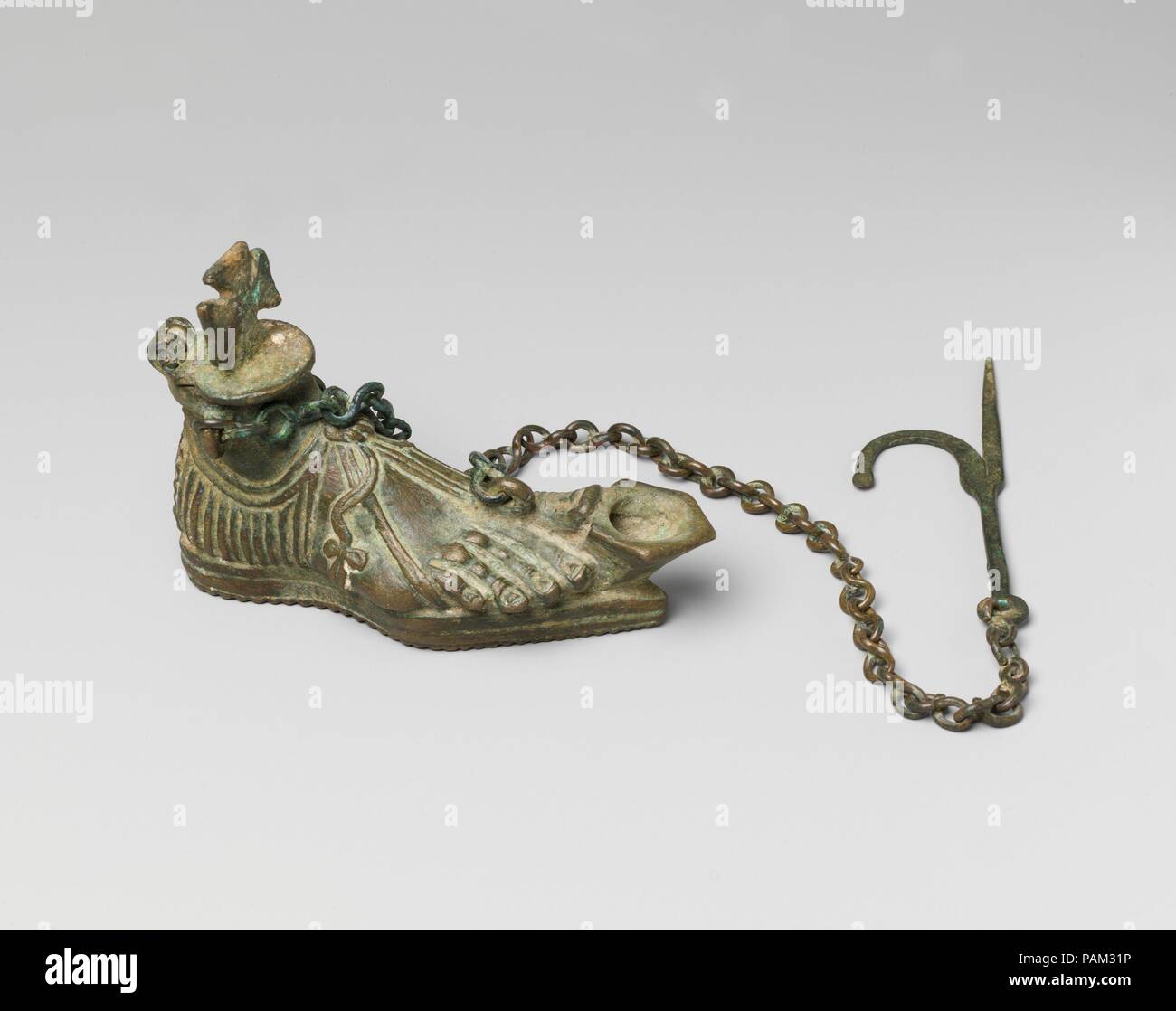 Lampe suspendue sous la forme d'un Sandaled pied droit. Culture : Byzantine. Dimensions : hors tout : 3 1/4 x 4 3/4 x 1 5/8 in. (8,3 x 12 x 4,2 cm) chaîne avec crochet : 17 1/8 x 1 1/4 x 3/16 in. (43,5 x 3,2 x 0,5 cm). Date : 5ème siècle. L'une des images de protection classique adapté par les Chrétiens a été le pied, un symbole de bonne santé et de guérison. Ces feux étaient allumés par une mèche imbibée d'huile, insérée dans le trou à côté du gros orteil du pied. Rond plat lampes suspendues, ou polycandela, étaient éclairées par des récipients en verre rempli d'huile accrochés aux trous ronds dans leurs dessins et modèles. Paul le Silentiary dans 563 décrit l'e Banque D'Images Lampe suspendue sous la forme d'un Sandaled pied droit. Culture : Byzantine. Dimensions : hors tout : 3 1/4 x 4 3/4 x 1 5/8 in. (8,3 x 12 x 4,2 cm) chaîne avec crochet : 17 1/8 x 1 1/4 x 3/16 in. (43,5 x 3,2 x 0,5 cm). Date : 5ème siècle. L'une des images de protection classique adapté par les Chrétiens a été le pied, un symbole de bonne santé et de guérison. Ces feux étaient allumés par une mèche imbibée d'huile, insérée dans le trou à côté du gros orteil du pied. Rond plat lampes suspendues, ou polycandela, étaient éclairées par des récipients en verre rempli d'huile accrochés aux trous ronds dans leurs dessins et modèles. Paul le Silentiary dans 563 décrit l'e Banque D'Images