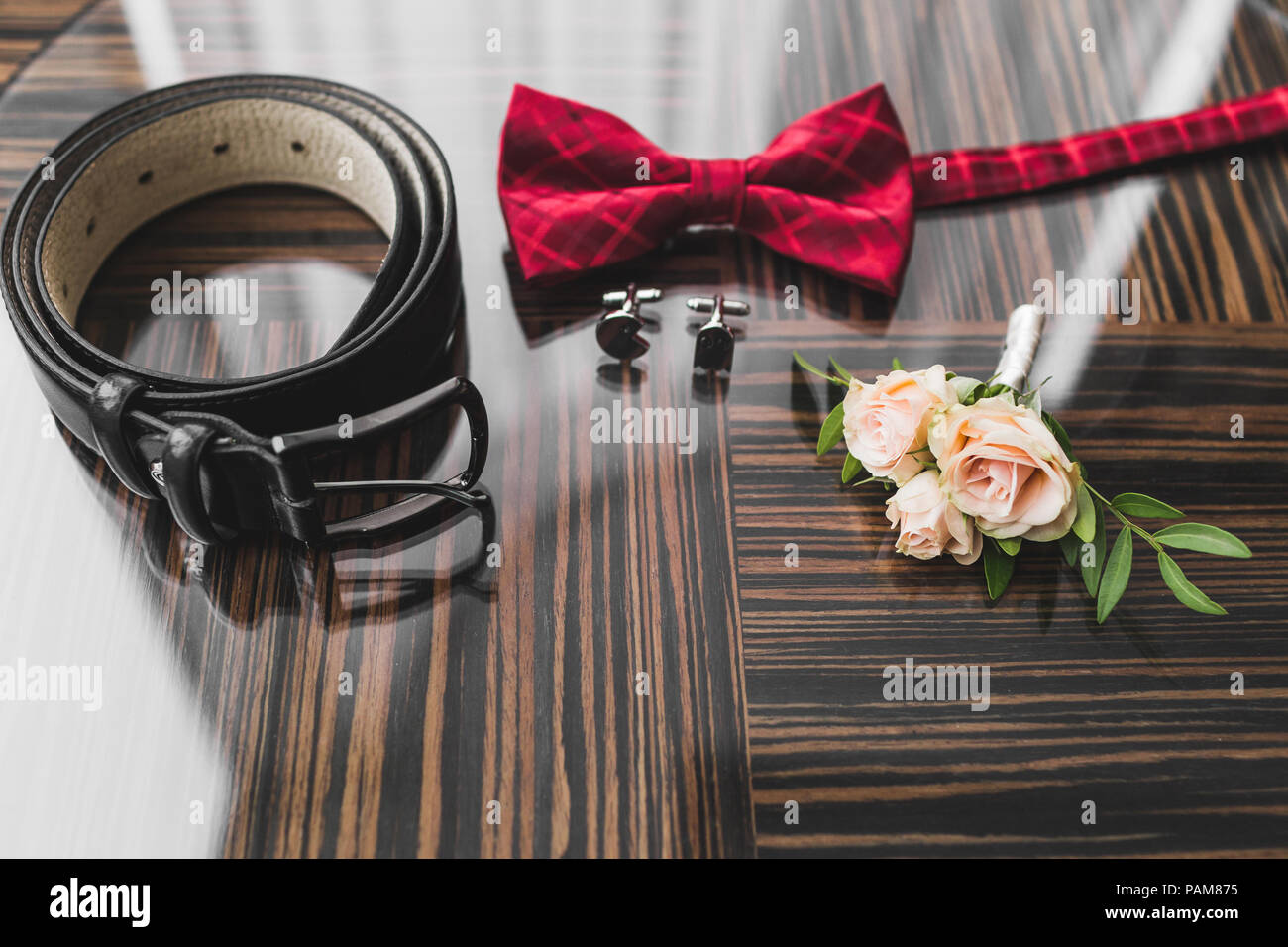 Homme mariage - rouge noeud papillon, Boutonnière de roses, boutons de  manchette et ceinture en cuir classique sur la texture en bois Photo Stock  - Alamy