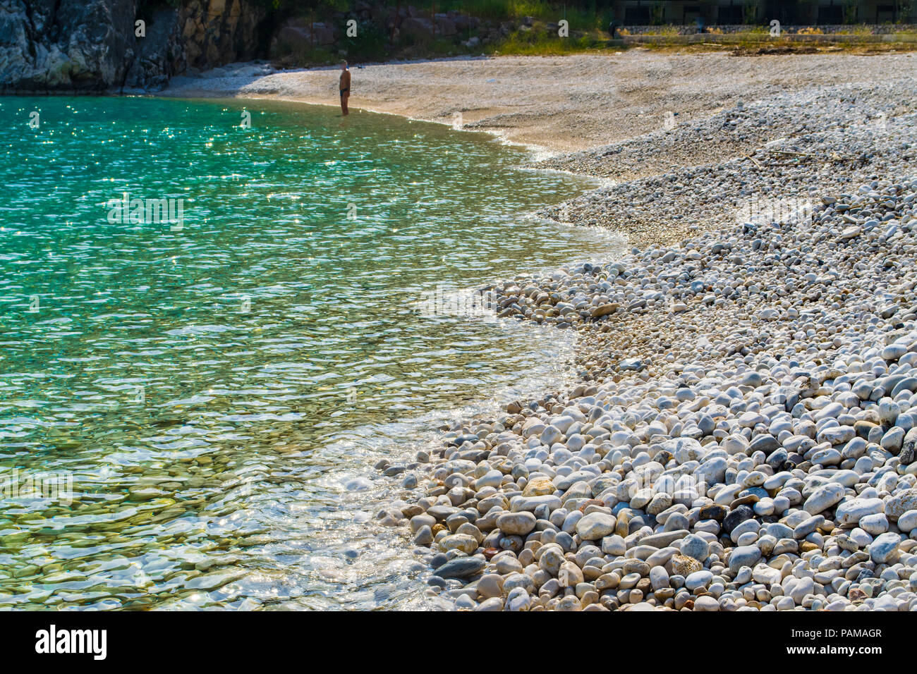 Les eaux cristallines de la mer turquoise d'une plage de galets. La plage de Poros en Grèce dans l'île Ionienne Leucade Banque D'Images