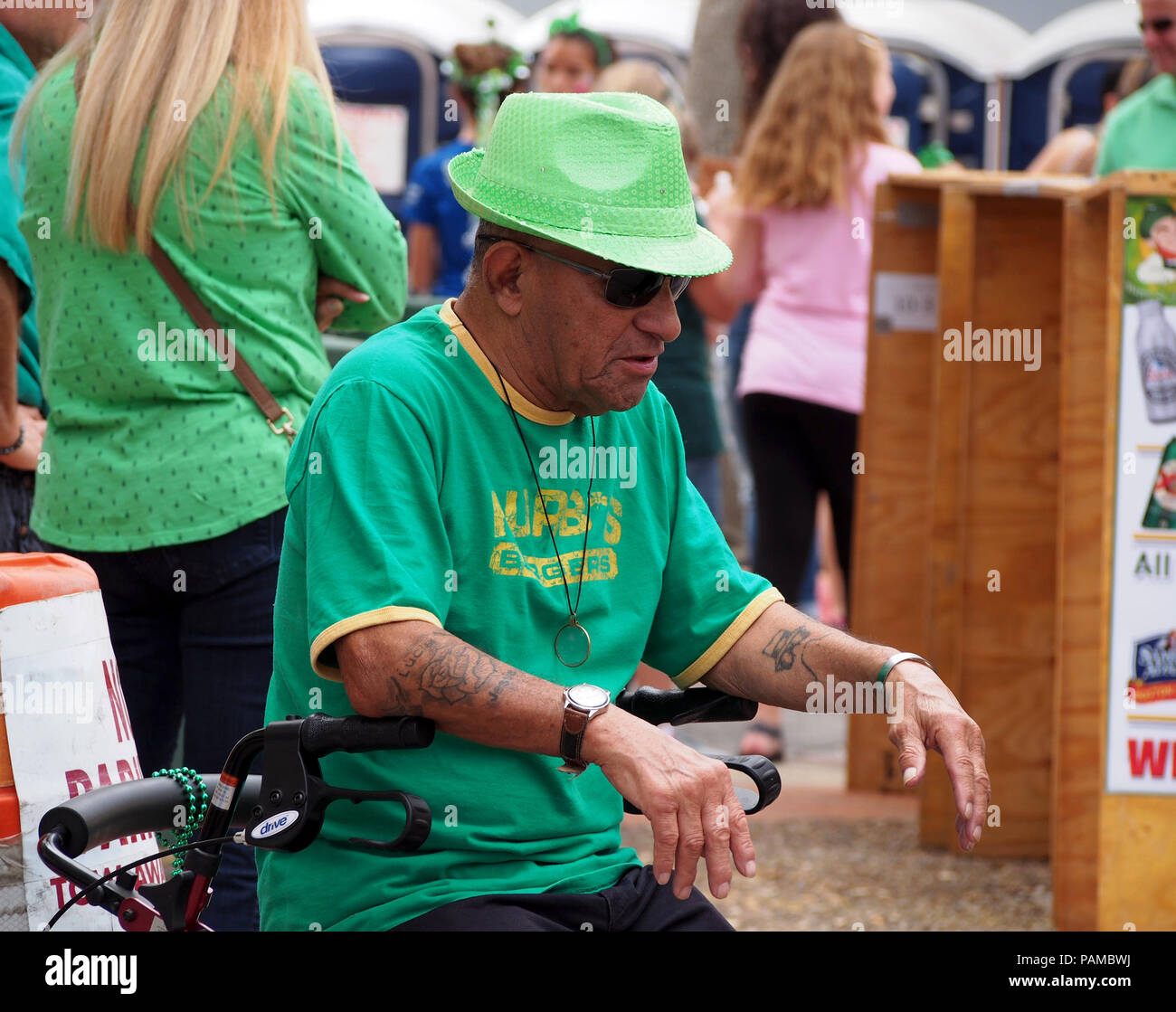 Un homme en assis sur sa marchette, semble être en appui à l'assemblée le jour de la Saint Patrick Festival Bloc de Corpus Christi, Texas USA. Banque D'Images
