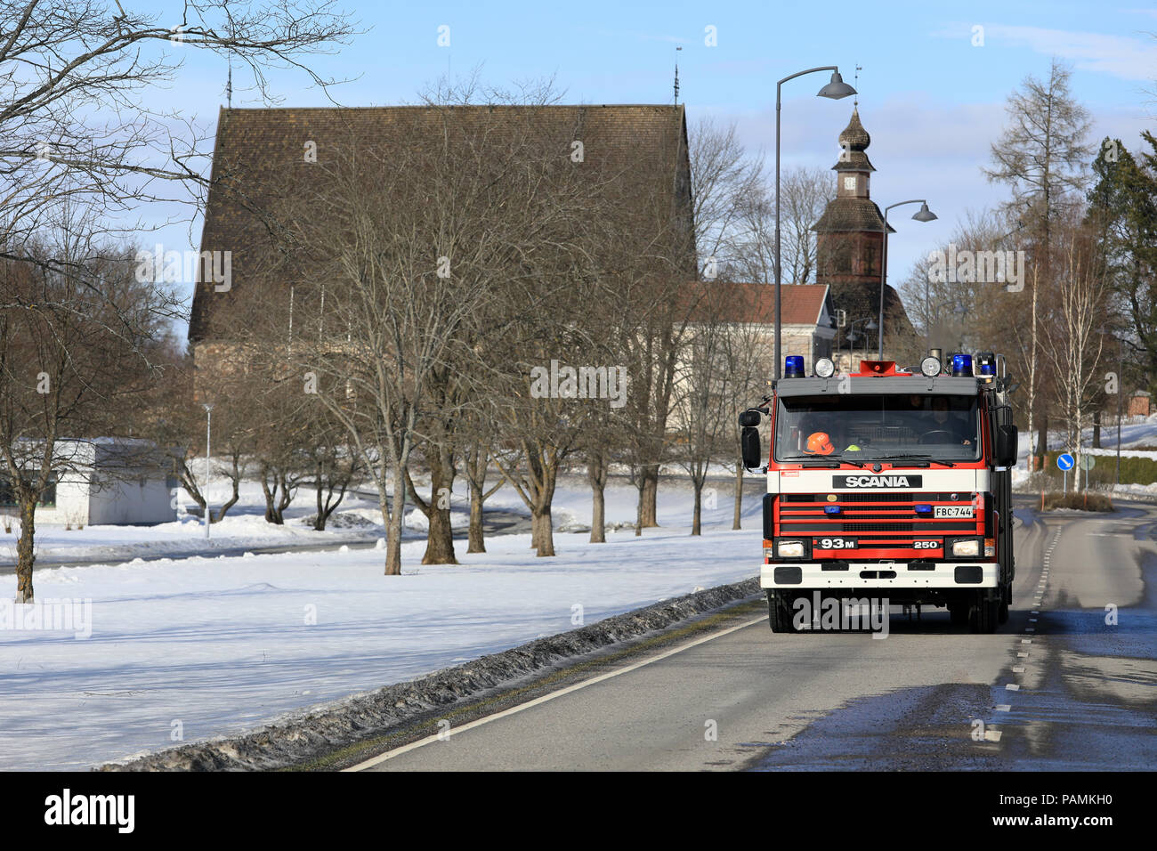 Scania 93M fire chariot roule sur la route dans le centre du village passé Pernio église médiévale sur l'arrière-plan. Pernio, Salo, Finlande - le 18 mars 2018. Banque D'Images