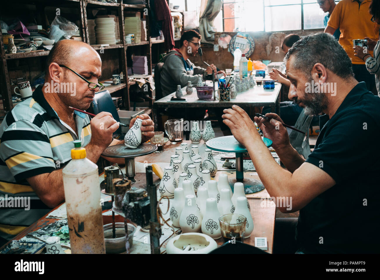 Deux potiers palestiniens donner une couche de peinture décorative pour certains d'argile blanche porcelaine Banque D'Images