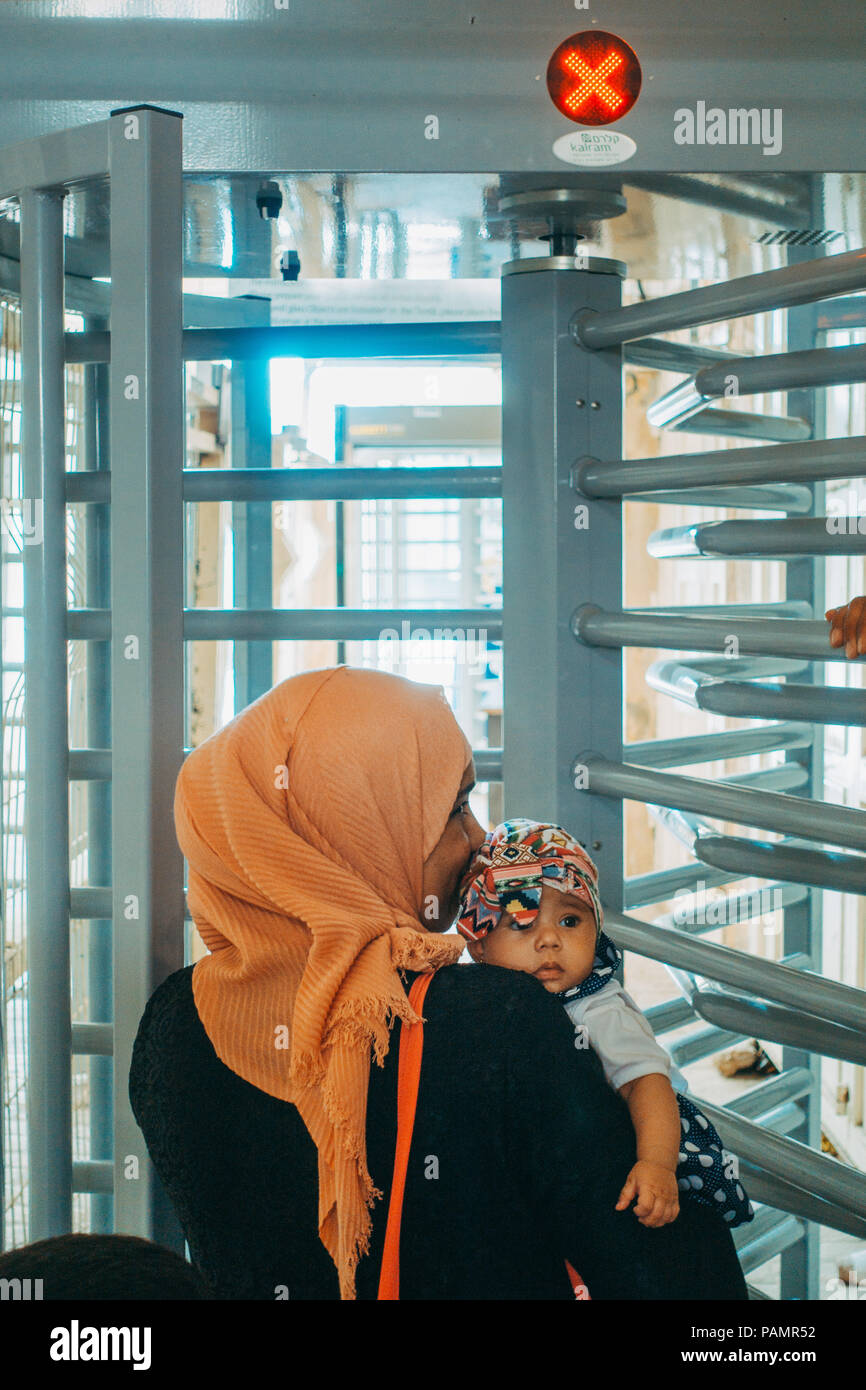 Une femme musulmane et bébé file d'attente à un poste de contrôle israélien avant d'être autorisés à entrer dans la mosquée au Caveau des patriarches à Hébron, en Cisjordanie occupée Banque D'Images