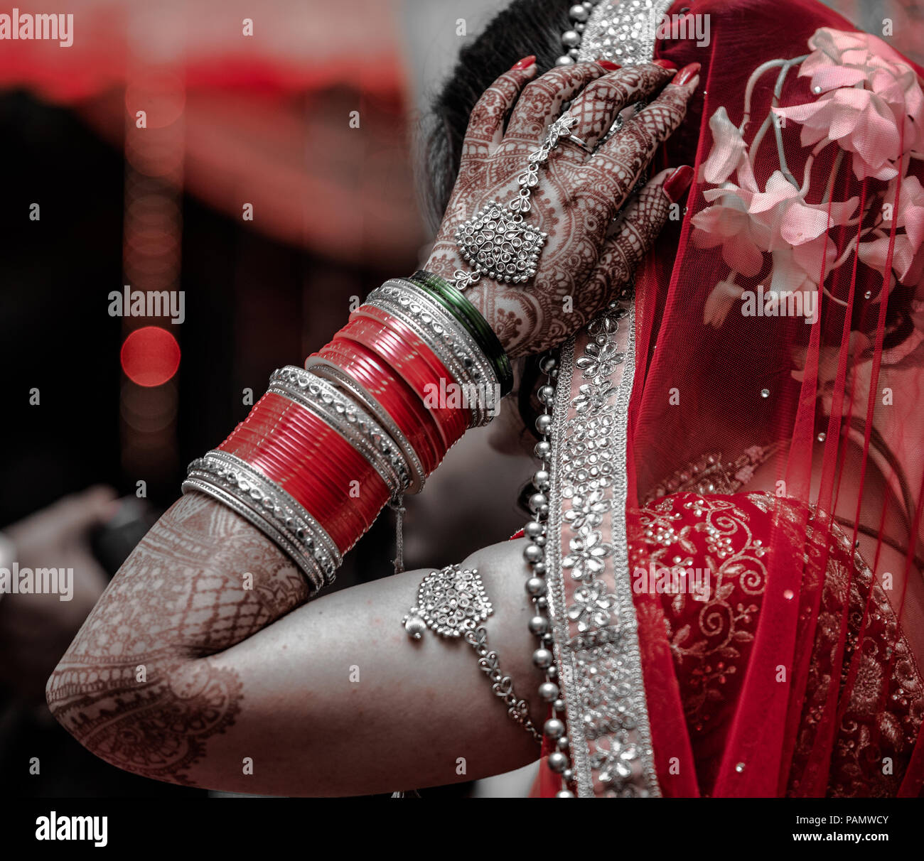 Photo de Candide belle mariée indienne en tenue traditionnelle portant des bracelets et de mariage robe rouge cramoisi en mariage hindou indien Banque D'Images