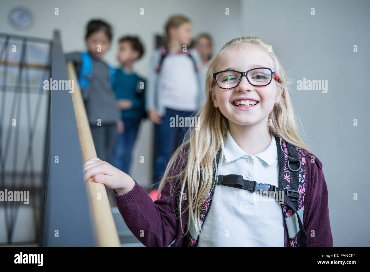 Portrait of happy schoolgirl avec ses camarades sur le départ de l'école d'escalier Banque D'Images