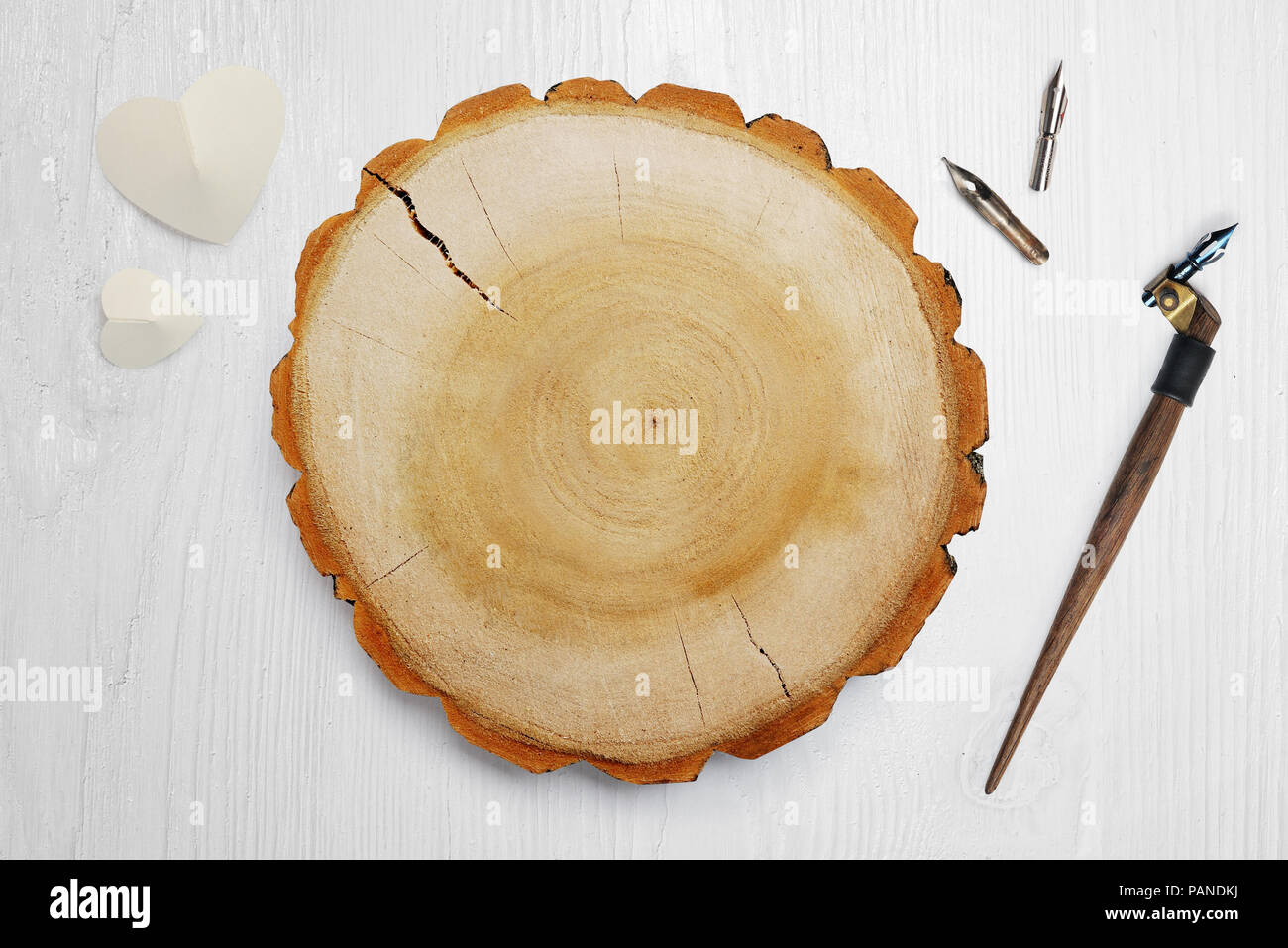 Plume calligraphique, se trouve à proximité d'un cercle en bois avec un papier blanc coeur. Mise à plat, haut voir photo maquette Banque D'Images