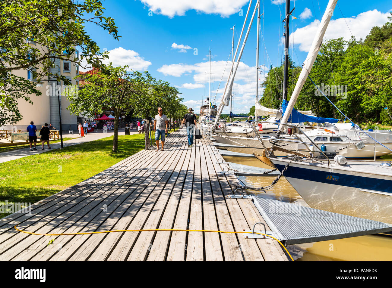Soderkoping, Suède - le 29 juin 2018 : journée d'été ordinaire le long le gota canal. Les gens qui marchent sur la promenade le long du canal avec bateaux amarrés à th Banque D'Images