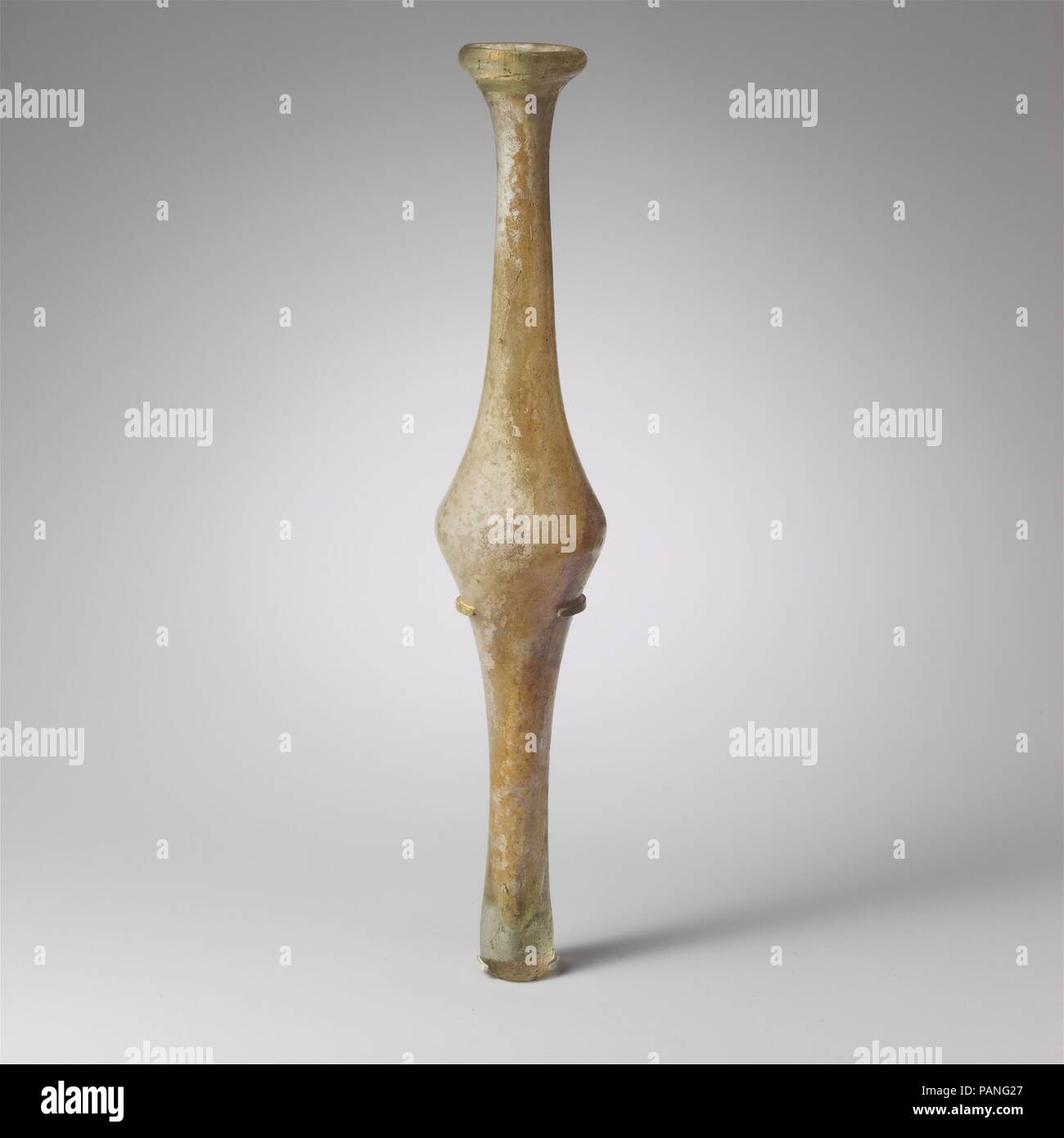 Flacon en verre et fusiforme. Culture : Roman. Dimensions : hors tout : 14 5/8 x 2 5/8 in. (37,2 x 6,7 cm). Date : 4ème siècle de notre ère. La teinte verte pâle à incolore. Solide, rebord arrondi, formant avec la lèvre de la coupe autour de petite bouche ; grand cou cylindrique, concave de profil, de rejoindre avec bi-conique au milieu du corps, puis le côté concave vers le bas pour l'extension d'épaisseur, fond plein, avec dénivelé, presque plat surface inférieure. Complet, sauf pour le grand trou du bas du corps et le bas, avec bords altérés ; beaucoup plus grande et piqûre d'émousser ; bulles, légères piqûres et faible sur l'extérieur, l'iridescence incruster du sol Banque D'Images