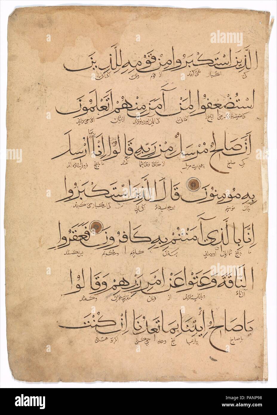 Folio à partir d'un Coran manuscrit. Dimensions : 19.5 in. high 14,00 in. de large (49,5 cm de haut 35,6 cm de large). Date : le 14e siècle. Ce Coran qui appartient probablement au xive siècle l'Iran est écrit en script muhaqqaq. Chaque feuillet comprend sept lignes avec traduction persane interlinéaire en écriture naskhi. Les versets 75-81de ce folio appartiennent à la dixième partie de la sourate al-A'raf (chapitre 7), qui donne le compte du Prophète Salih et Lot. Le médaillon marginal sur le verso est utilisée pour fins d'ornement. Musée : Metropolitan Museum of Art, New York, USA. Banque D'Images