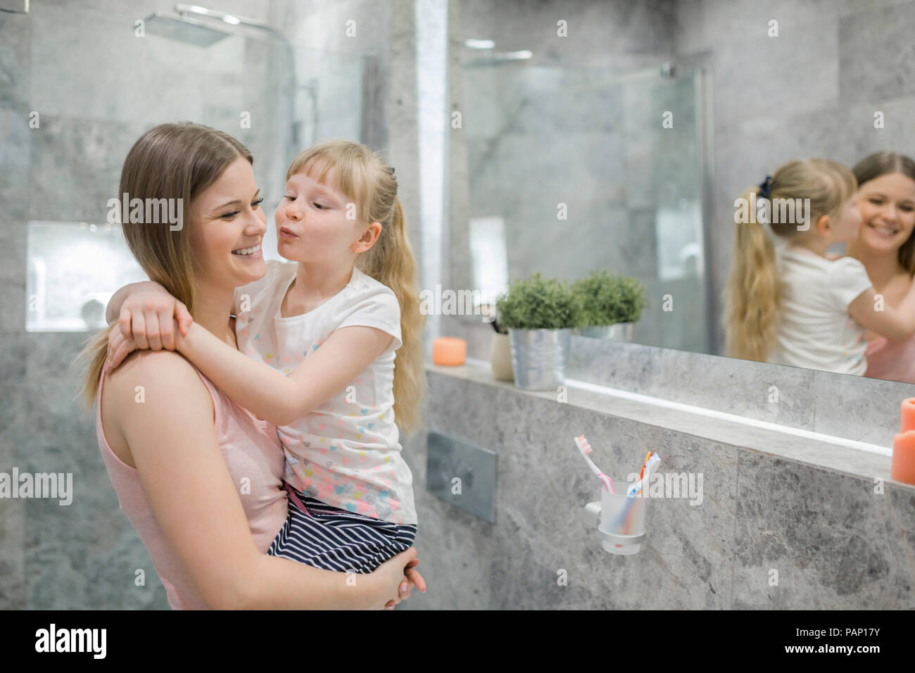 Petite fille embrassant sa maman dans la salle de bains Banque D'Images