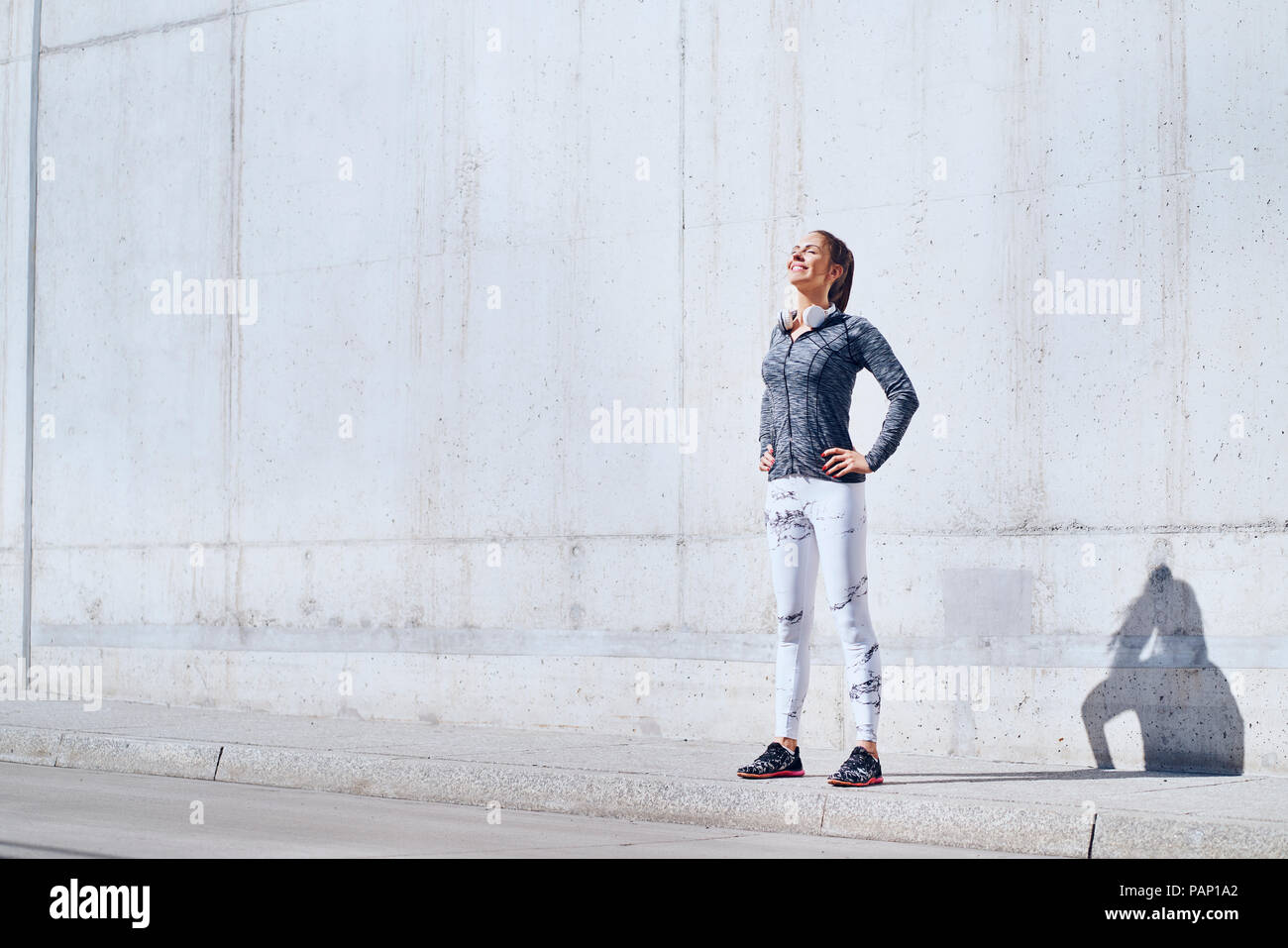Female jogger profiter journée ensoleillée au cours de l'entraînement en milieu urbain Banque D'Images Female jogger profiter journée ensoleillée au cours de l'entraînement en milieu urbain Banque D'Images