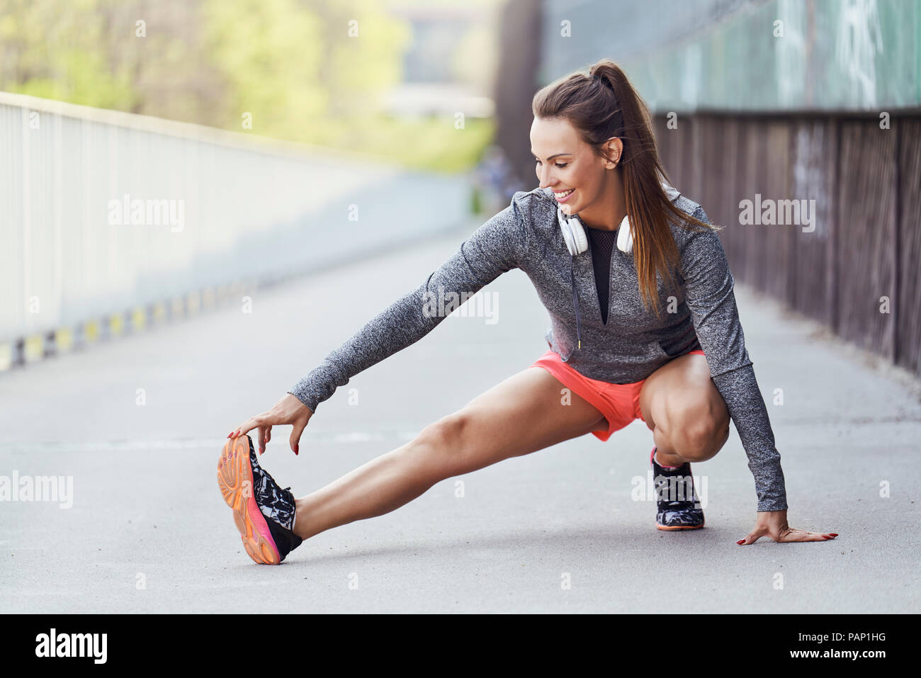 Female runner stretching jambes pendant l'entraînement en milieu urbain Banque D'Images Female runner stretching jambes pendant l'entraînement en milieu urbain Banque D'Images