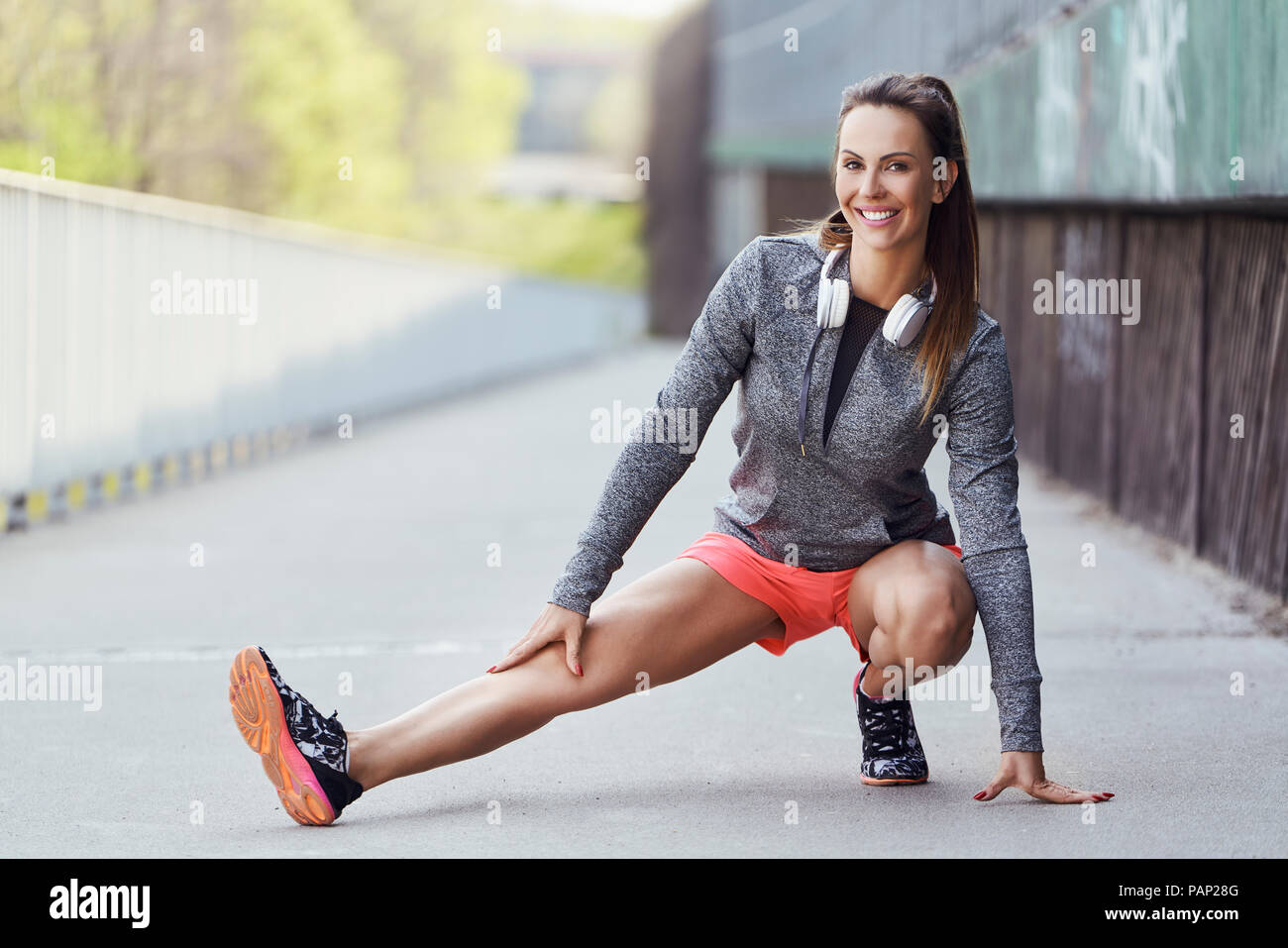 Female runner stretching jambes pendant l'entraînement en milieu urbain Banque D'Images