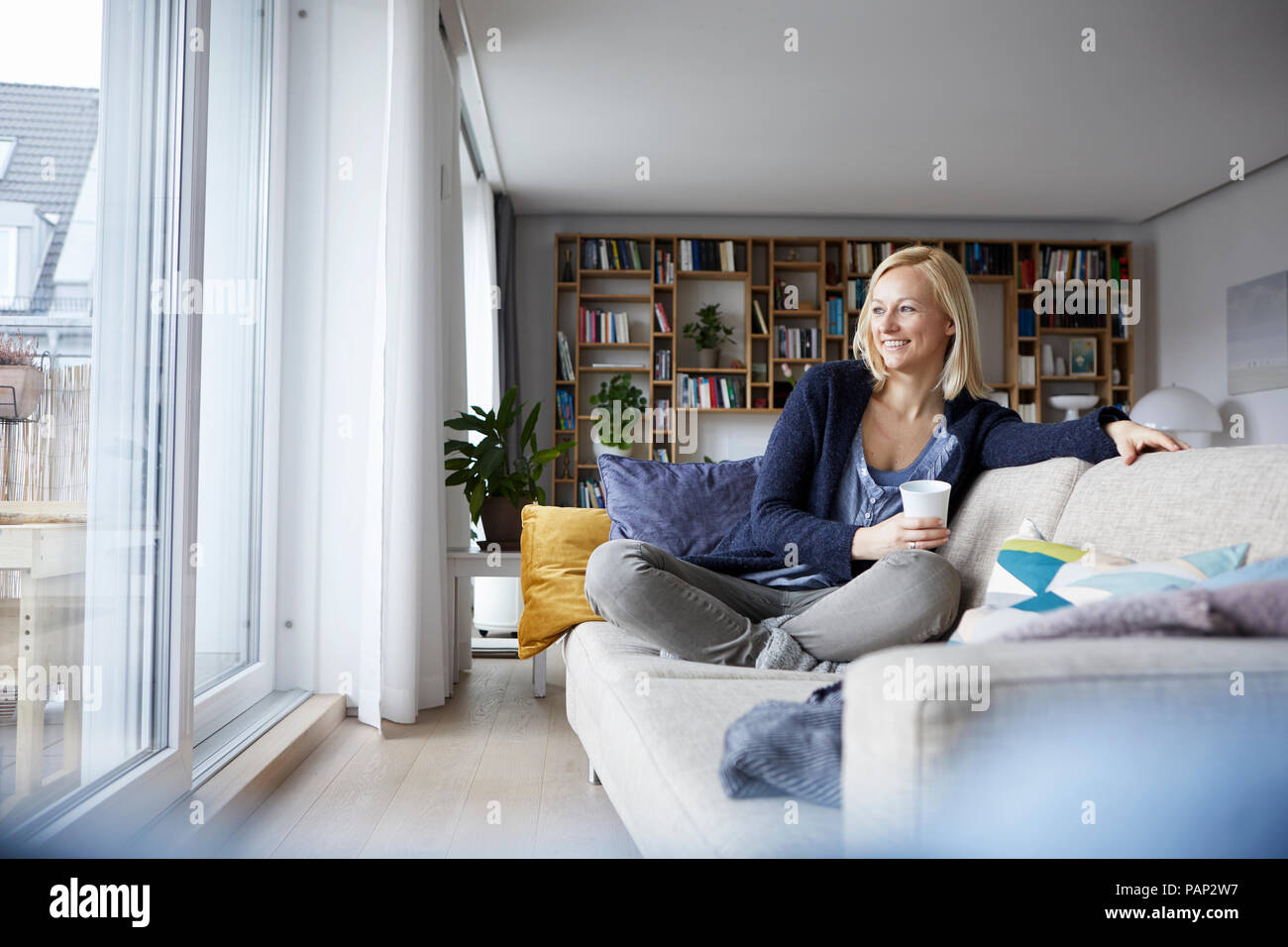 Woman relaxing at home, sitting on couch Banque D'Images