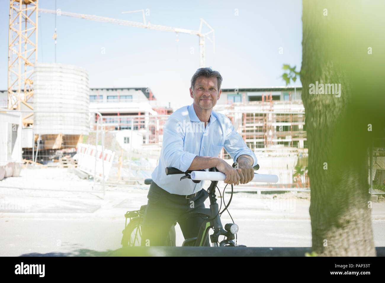 Portrait d'homme avec e-bike on construction site Banque D'Images