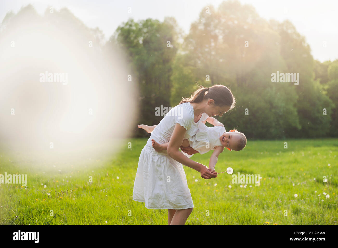 Mère et fille jouer sur prairie en été Banque D'Images