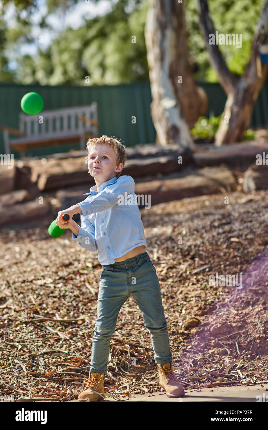 Boy in garden jouant avec mousse baseball bat and ball Banque D'Images