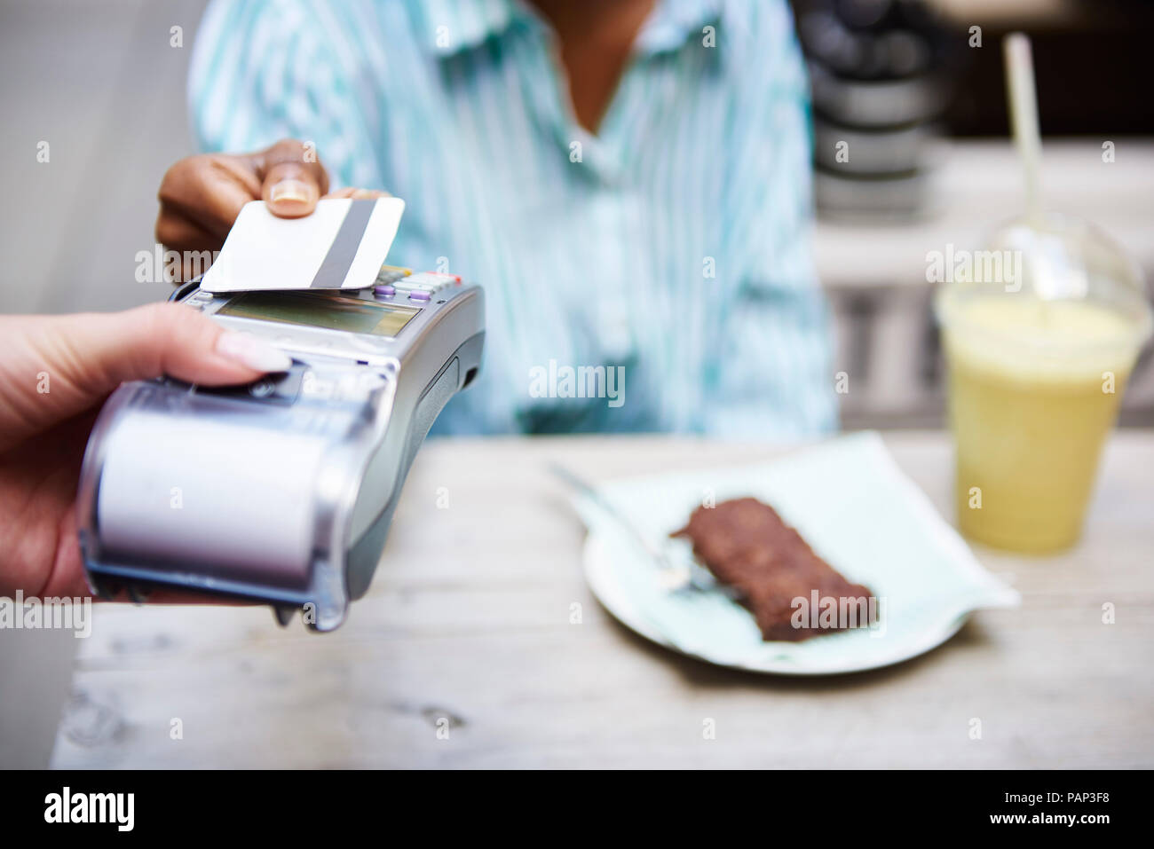 Femme de payer par carte de crédit au café de la chaussée, close-up Banque D'Images