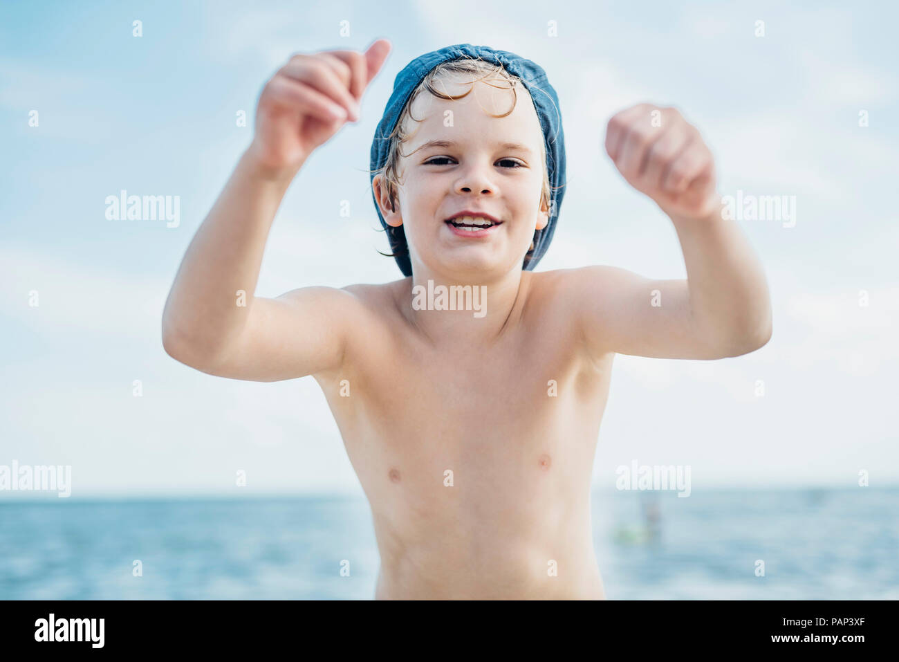 Portrait of happy boy portant une casquette à la mer Banque D'Images