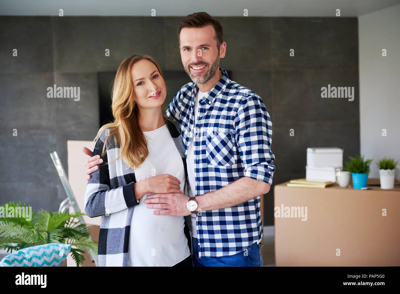 Portrait d'homme heureux et femme enceinte en télévision Banque D'Images